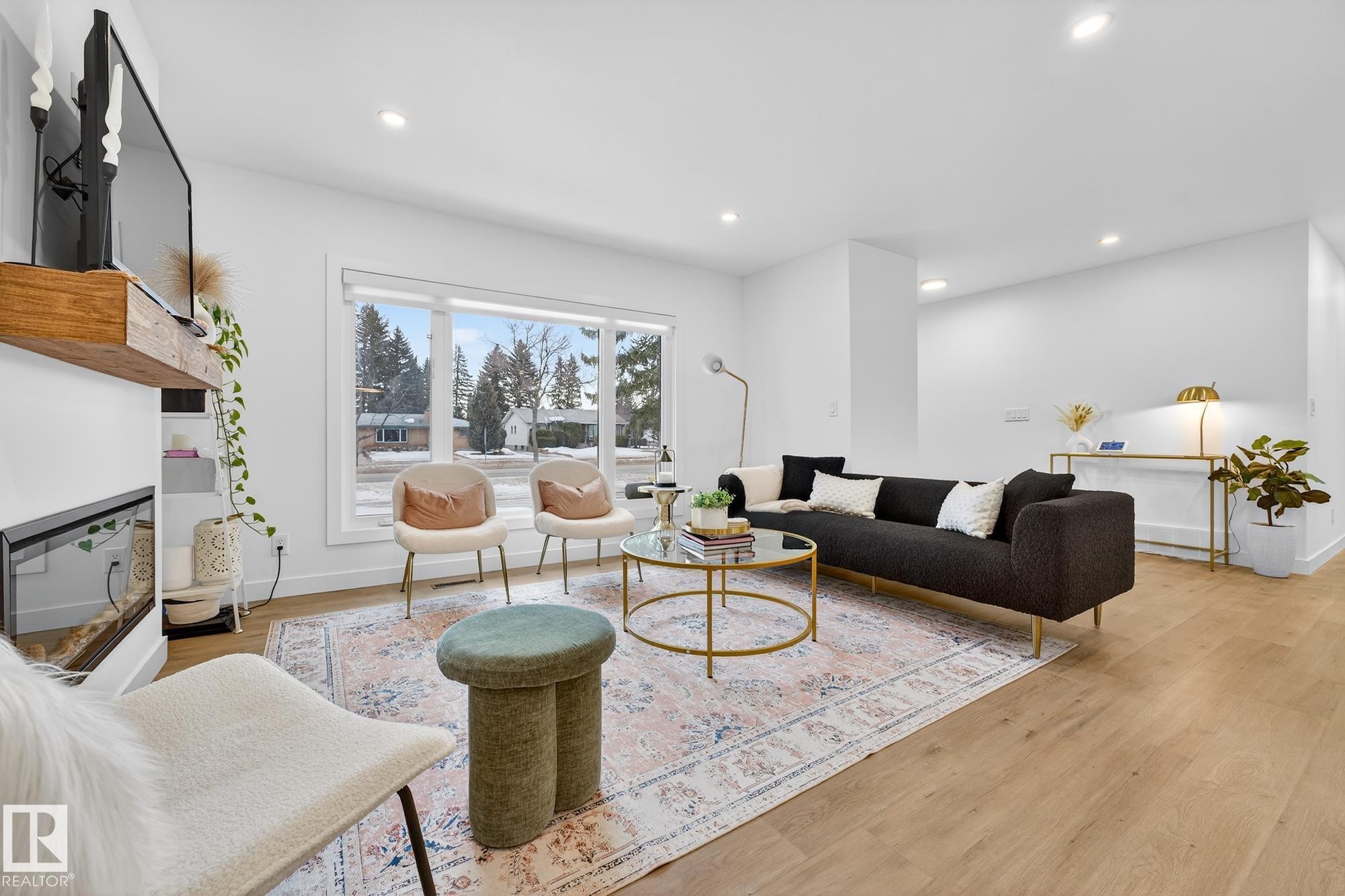Living area with light wood-style flooring, a multi sided fireplace, and recessed lighting - 8604 142 Street, Edmonton, AB - Indoor Photo Showing Living Room With Fireplace