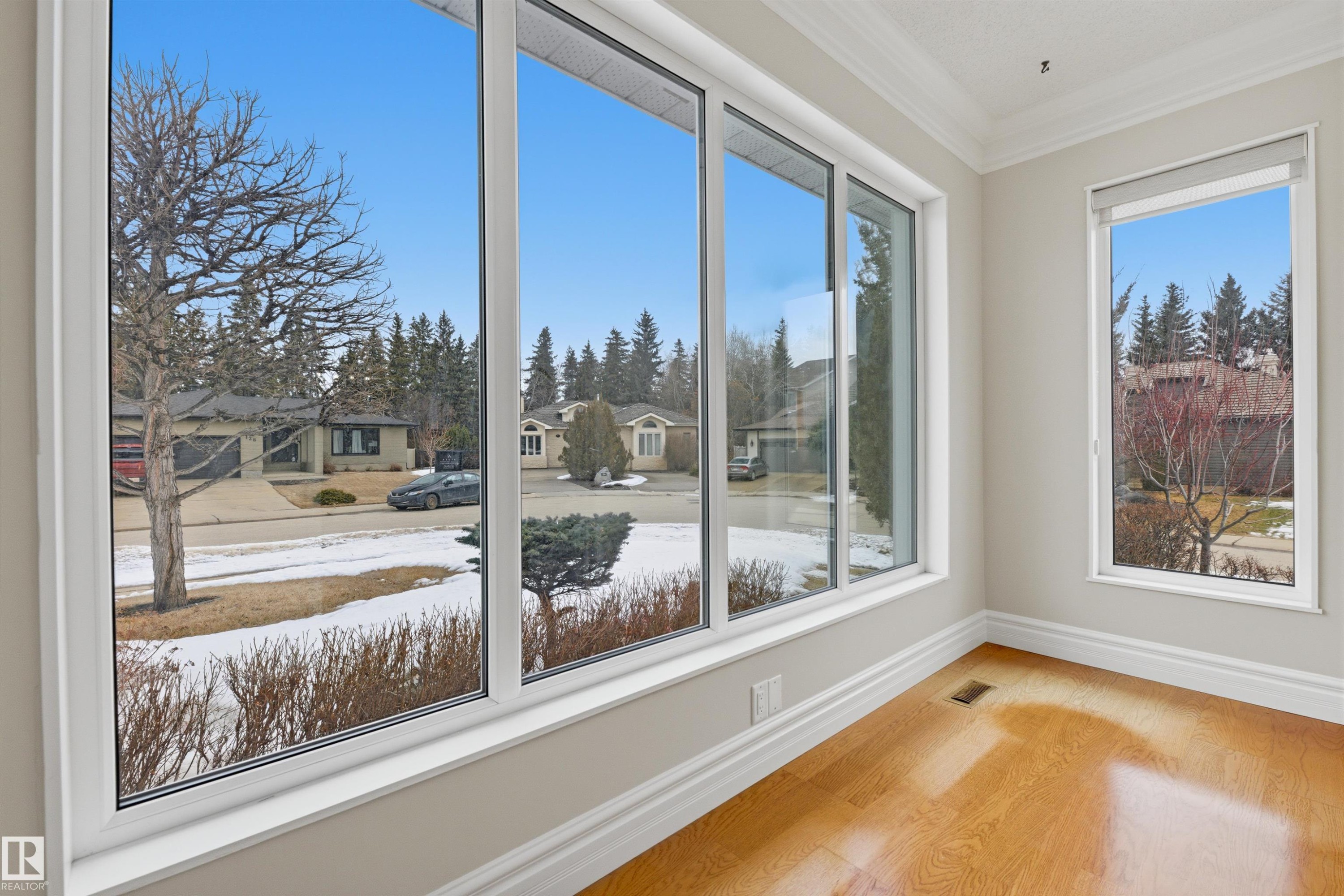 This room features large windows with white frames, offering views of the surrounding neighborhood - 131 Walsh Crescent, Edmonton, AB - Indoor Photo Showing Other Room