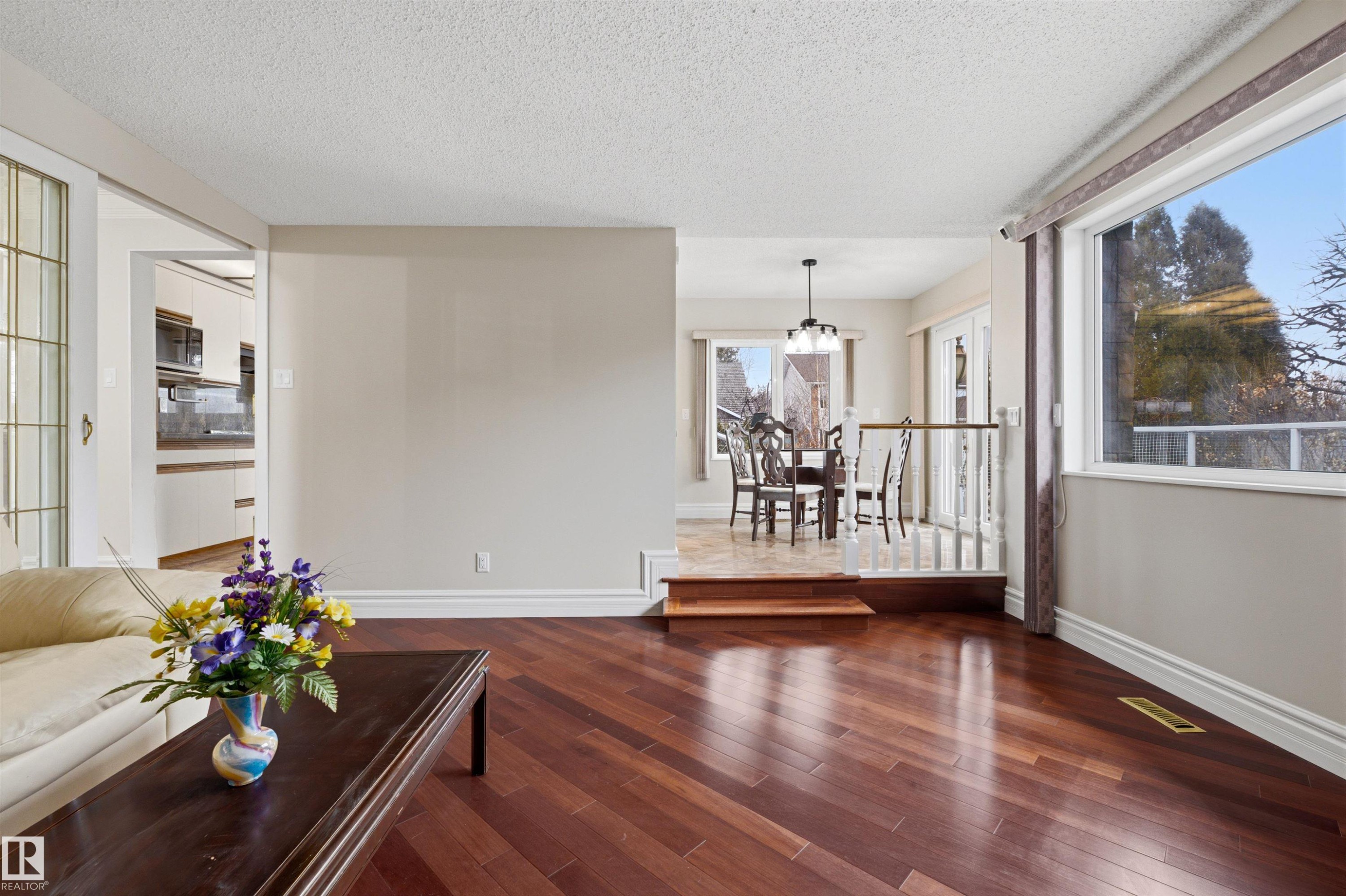 The interior of the property features rich hardwood flooring and large windows, providing views of the outdoors - 131 Walsh Crescent, Edmonton, AB - Indoor Photo Showing Other Room
