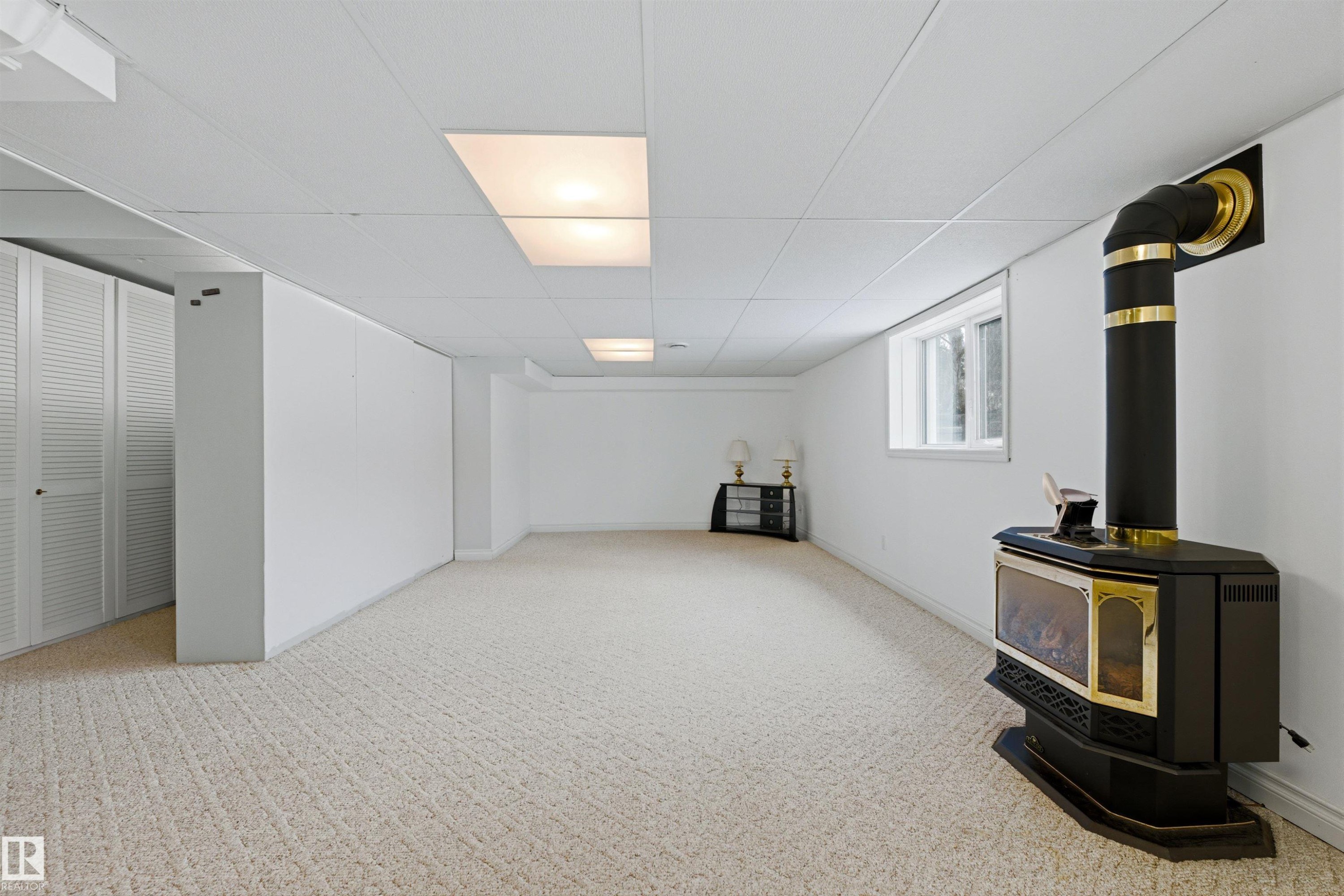Spacious room featuring carpeting, a white drop ceiling with recessed lighting, and a window providing natural light - 131 Walsh Crescent, Edmonton, AB - Indoor Photo Showing Other Room