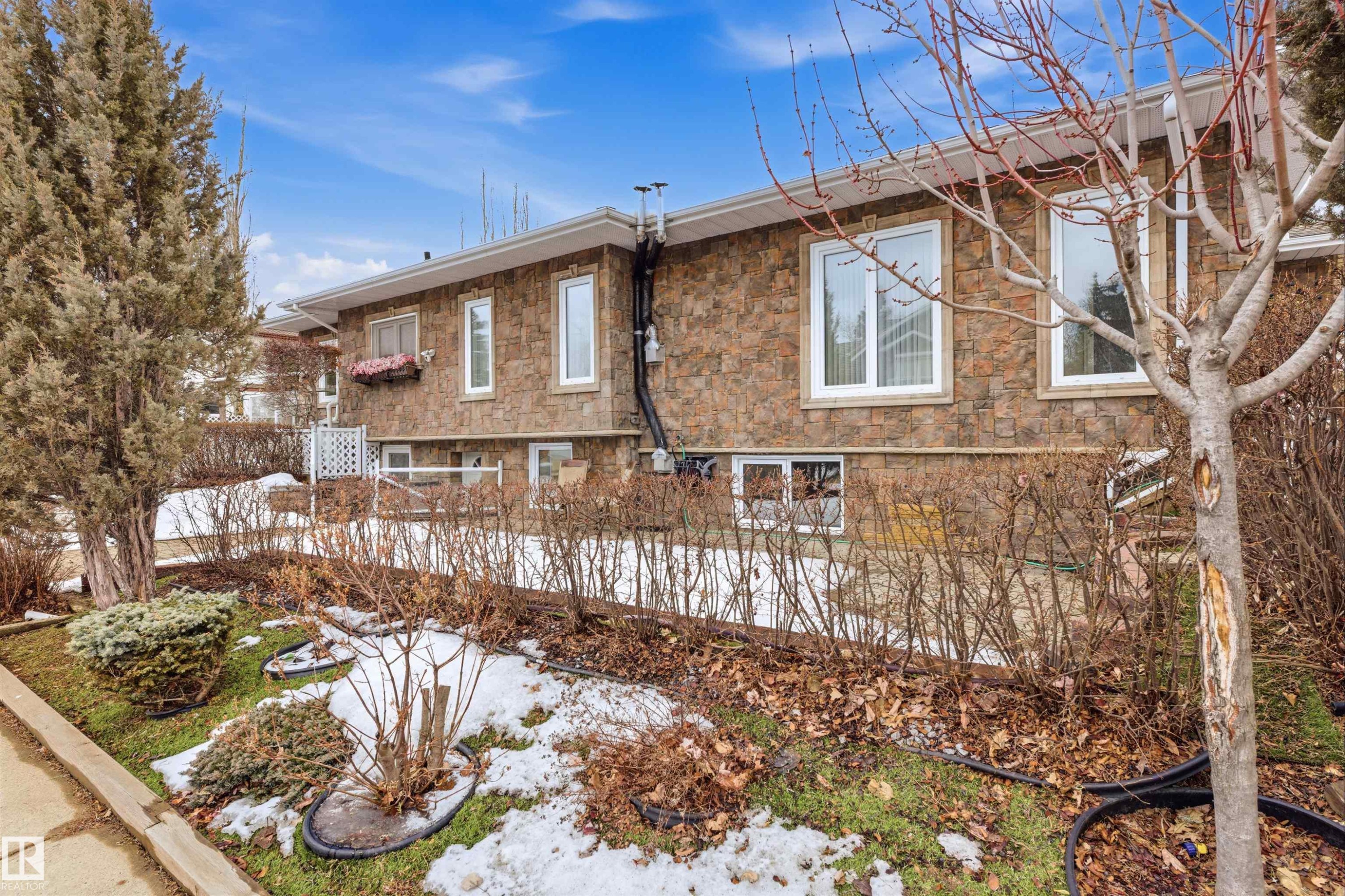 The property features a stone exterior and white window frames - 131 Walsh Crescent, Edmonton, AB - Outdoor