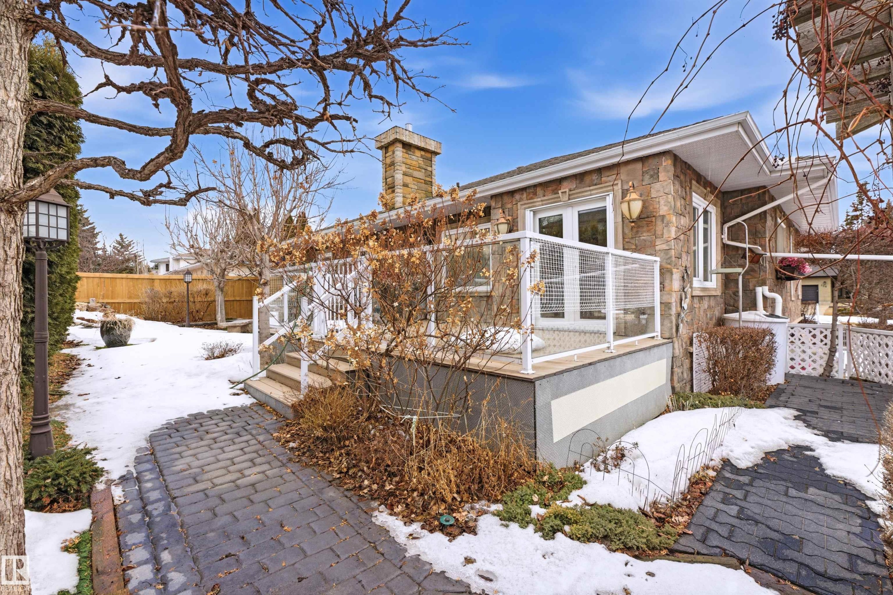 The property features an exterior with stone cladding and a patio area with a glass railing - 131 Walsh Crescent, Edmonton, AB - Outdoor