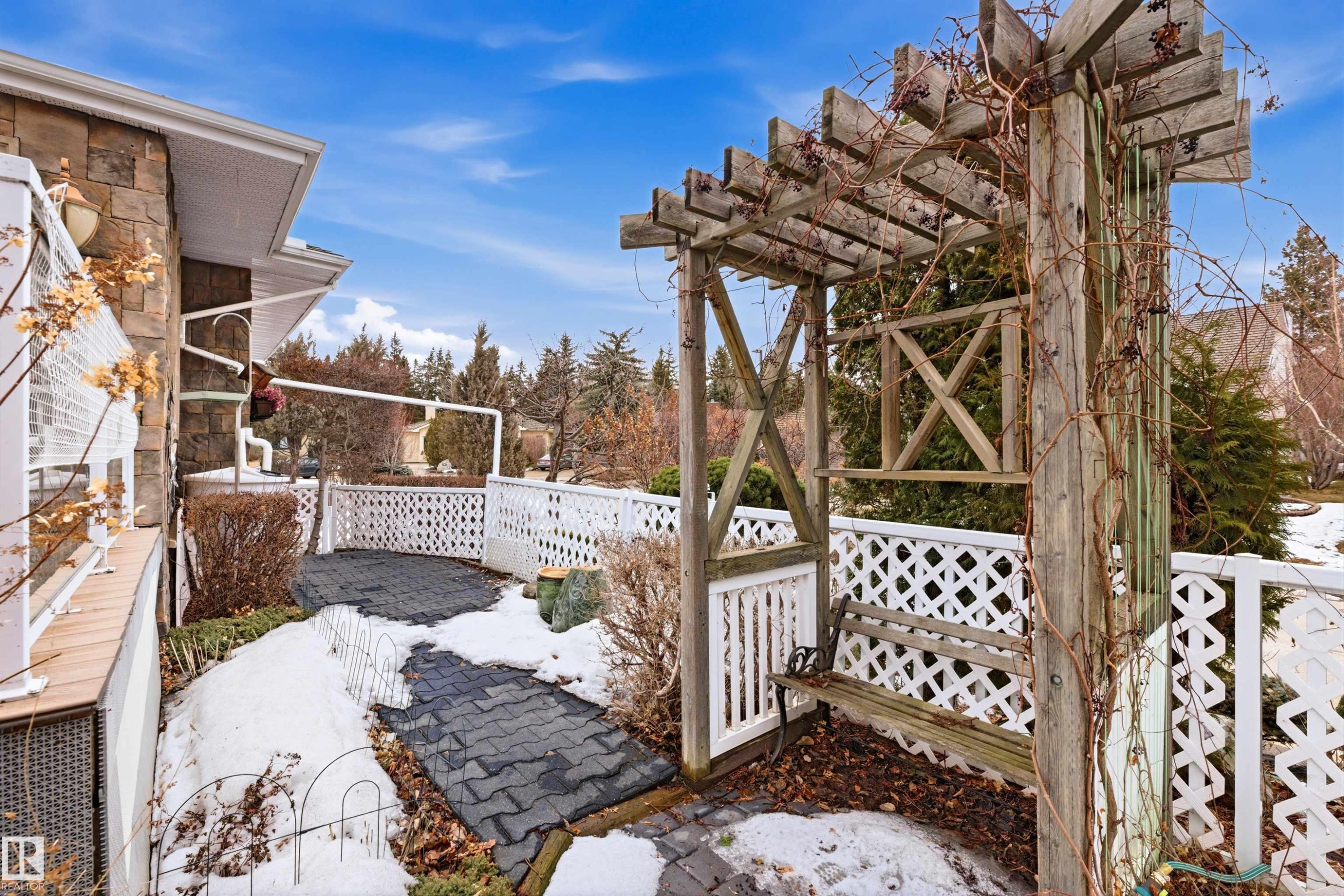 The property features a stone exterior and a patio area with dark paving stones - 131 Walsh Crescent, Edmonton, AB - Outdoor