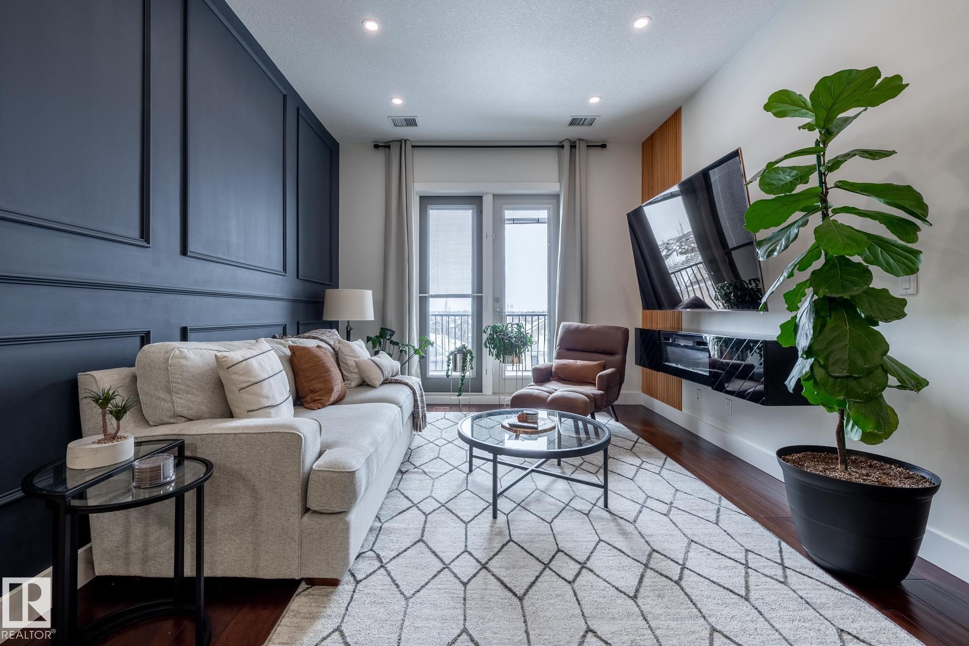 The living area features hardwood floors and recessed lighting - 454 6079 Maynard Way, Edmonton, AB - Indoor Photo Showing Other Room
