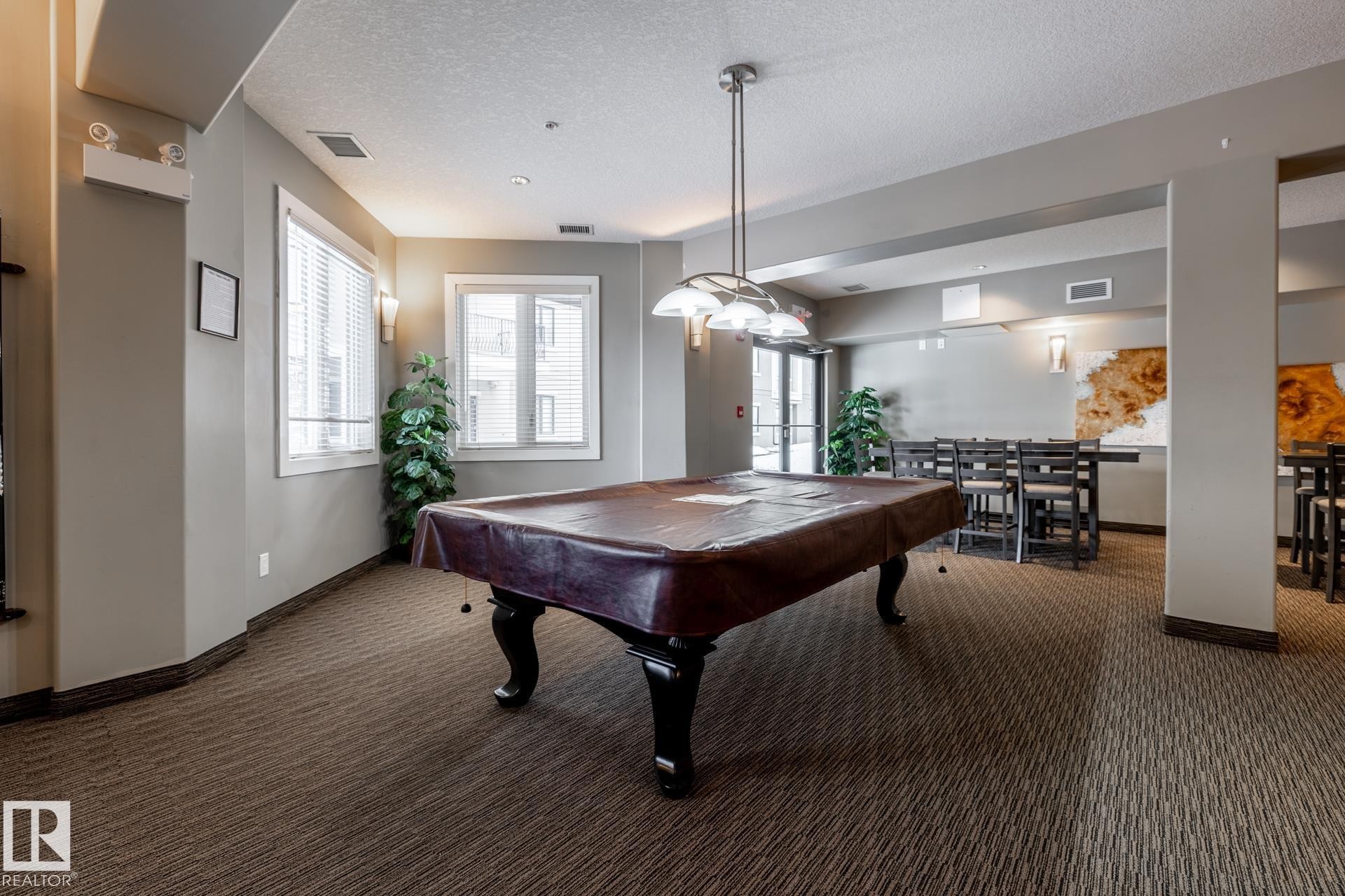 The entertainment room features a pool table with a brown cover, carpeted flooring, and recessed lighting - 454 6079 Maynard Way, Edmonton, AB - Indoor Photo Showing Other Room