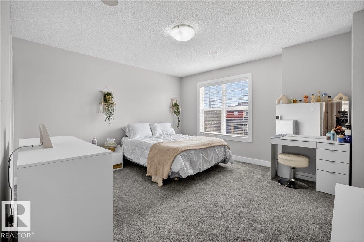 This room features light grey walls and grey carpet, creating a neutral aesthetic - 9034 Rosenthal Link, Edmonton, AB - Indoor Photo Showing Bedroom