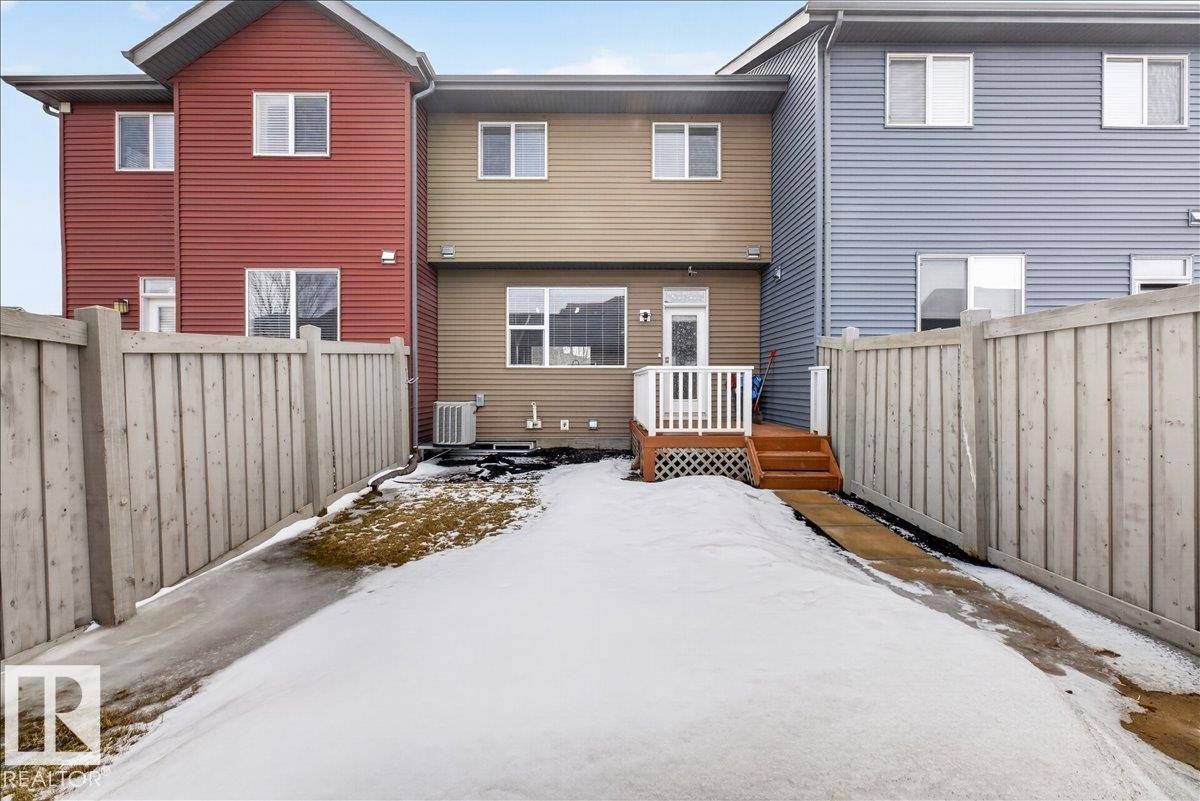 The property features a fenced yard, a wooden deck, and a glass sliding door - 9034 Rosenthal Link, Edmonton, AB - Outdoor With Exterior