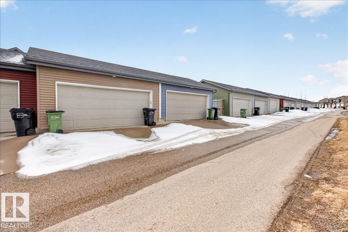 Attached garage with light-colored siding and a matching garage door - 9034 Rosenthal Link, Edmonton, AB - Outdoor
