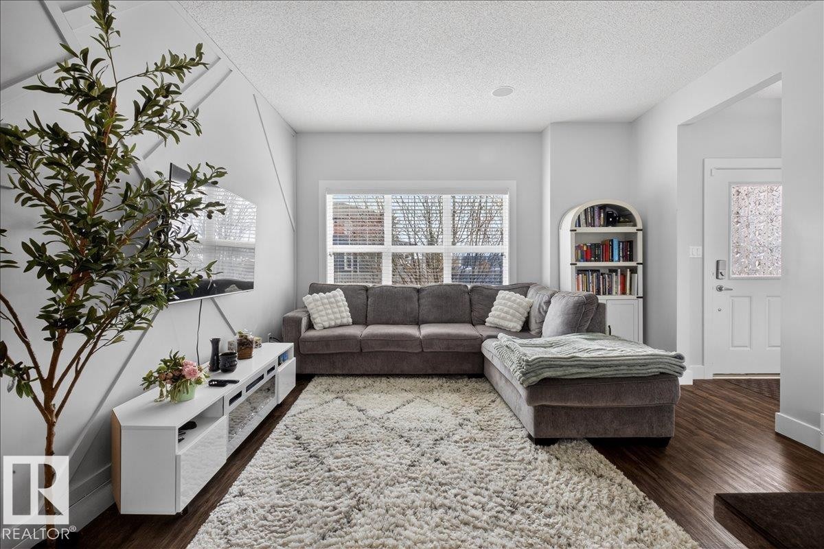 Living area featuring rich dark wood flooring and light-colored walls - 9034 Rosenthal Link, Edmonton, AB - Indoor Photo Showing Living Room