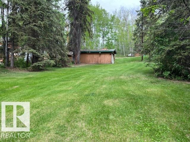 Expansive green lawn surrounded by mature evergreen trees and deciduous foliage - 1040 &1040 A&B Mitchell Beach Beach, Rural Leduc County, AB