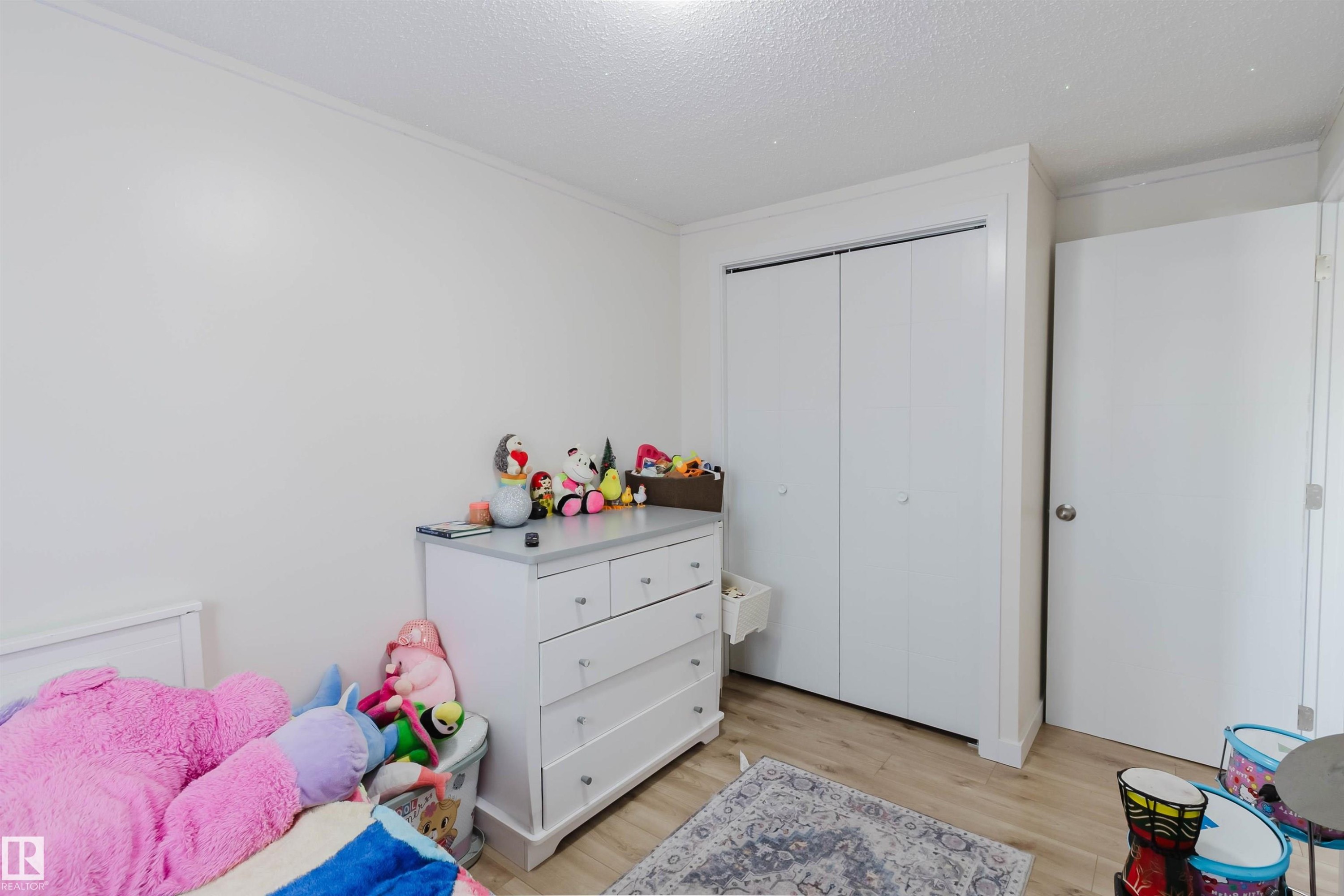 This room features light-colored walls, a closet with bi-fold doors, and light-toned flooring - 18088 93 Avenue Nw, Edmonton, AB - Indoor Photo Showing Bedroom