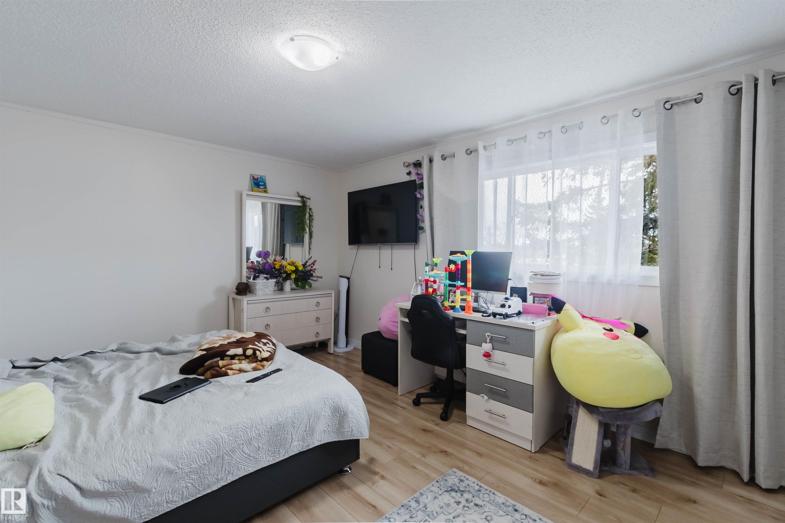 Bedroom featuring light-colored walls, a window with sheer and opaque curtains, and light wood flooring - 18088 93 Avenue Nw, Edmonton, AB - Indoor Photo Showing Bedroom