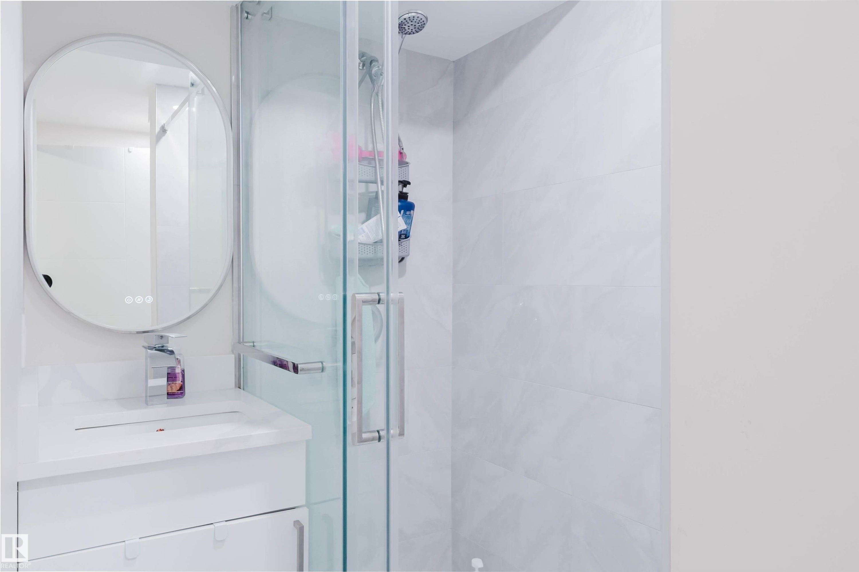 Bathroom featuring a glass-enclosed shower, a vanity with an integrated sink, and a modern oval mirror - 18088 93 Avenue Nw, Edmonton, AB - Indoor Photo Showing Bathroom
