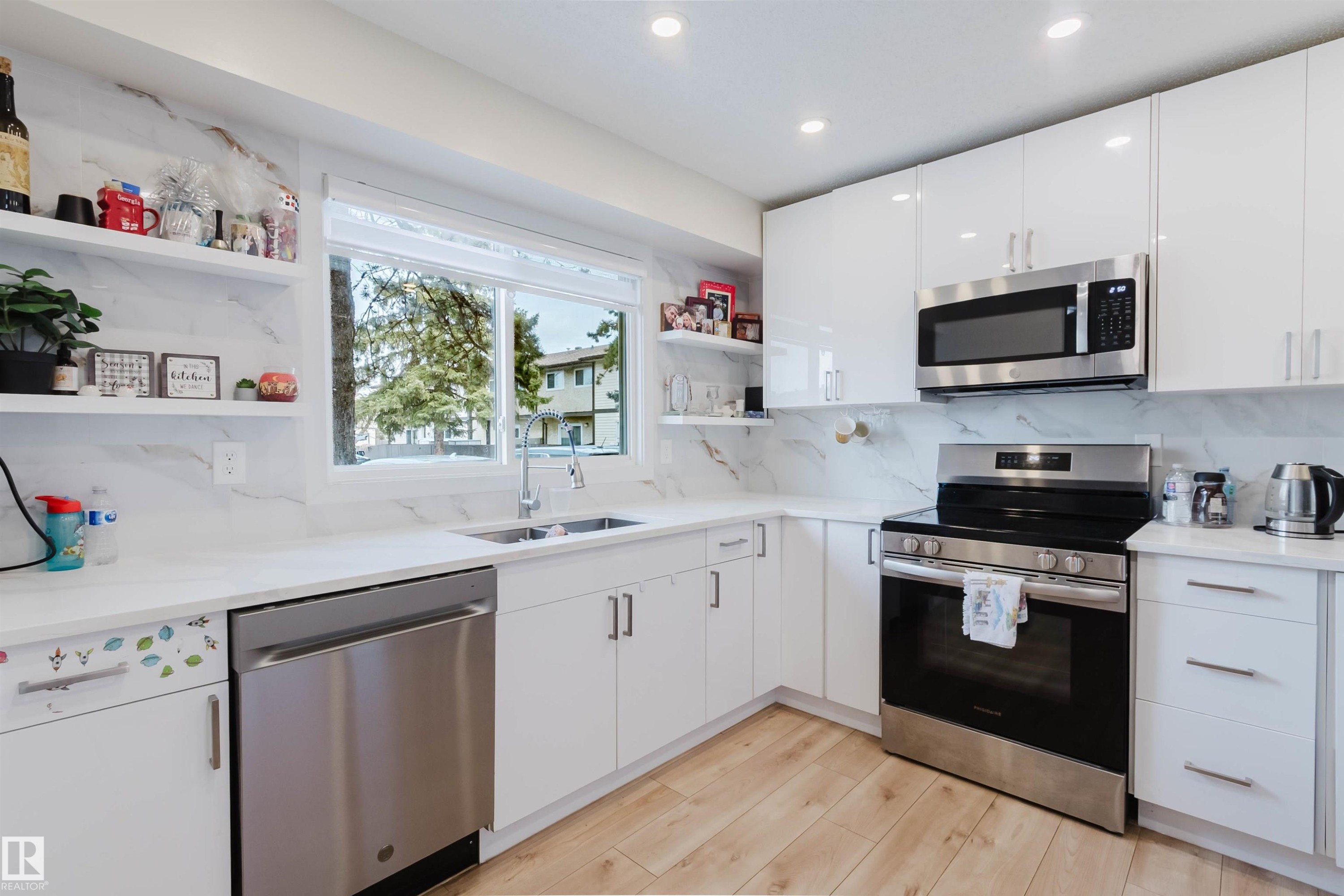The kitchen features white cabinetry, white countertops, and a white backsplash with gray veining - 18088 93 Avenue Nw, Edmonton, AB - Indoor Photo Showing Kitchen With Double Sink