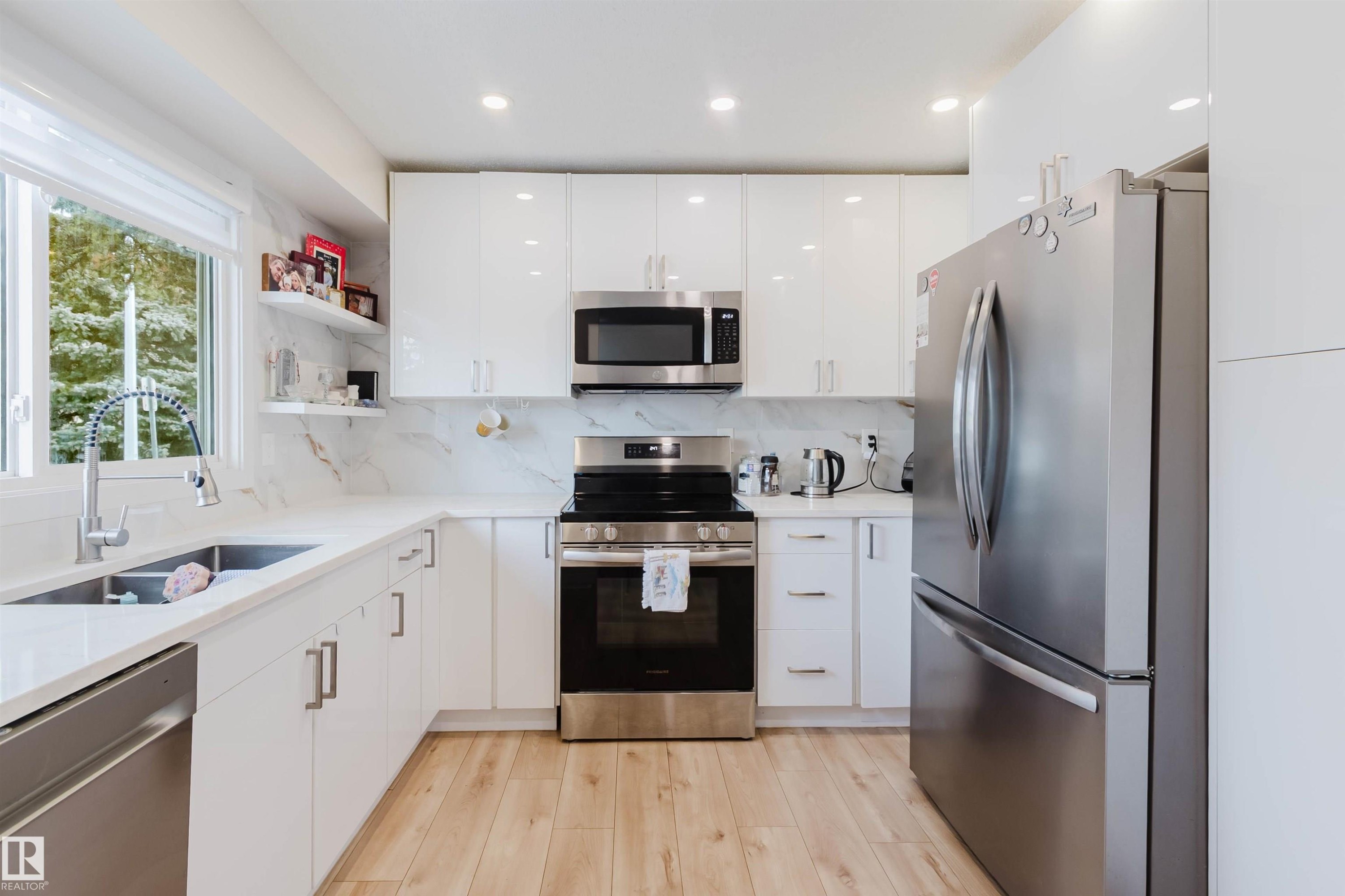 The kitchen features white cabinetry, stainless steel appliances, and light-toned flooring - 18088 93 Avenue Nw, Edmonton, AB - Indoor Photo Showing Kitchen With Double Sink