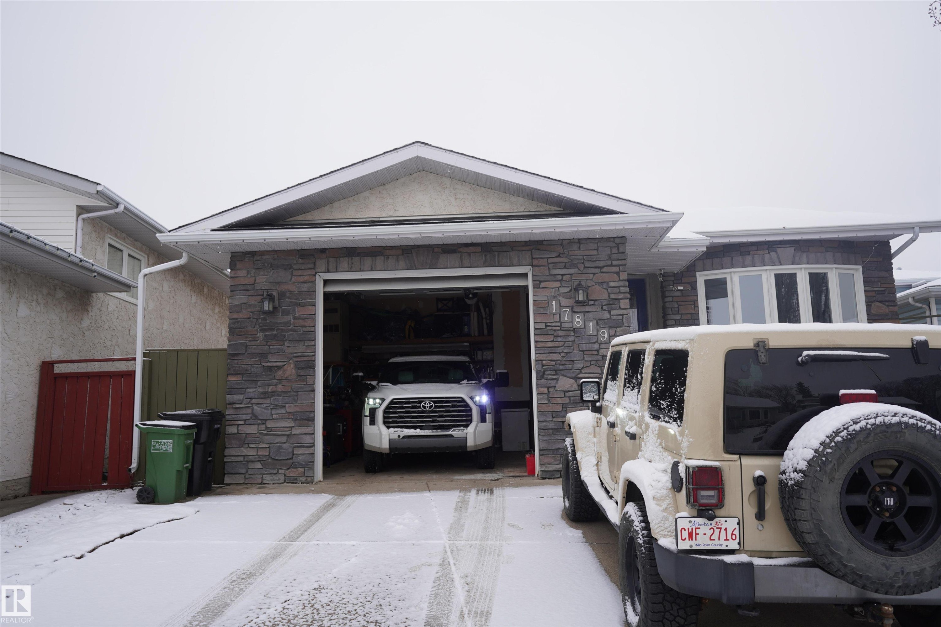 The property features an attached garage with an automatic door and a stone facade - 17819 91A Street, Edmonton, AB - Outdoor