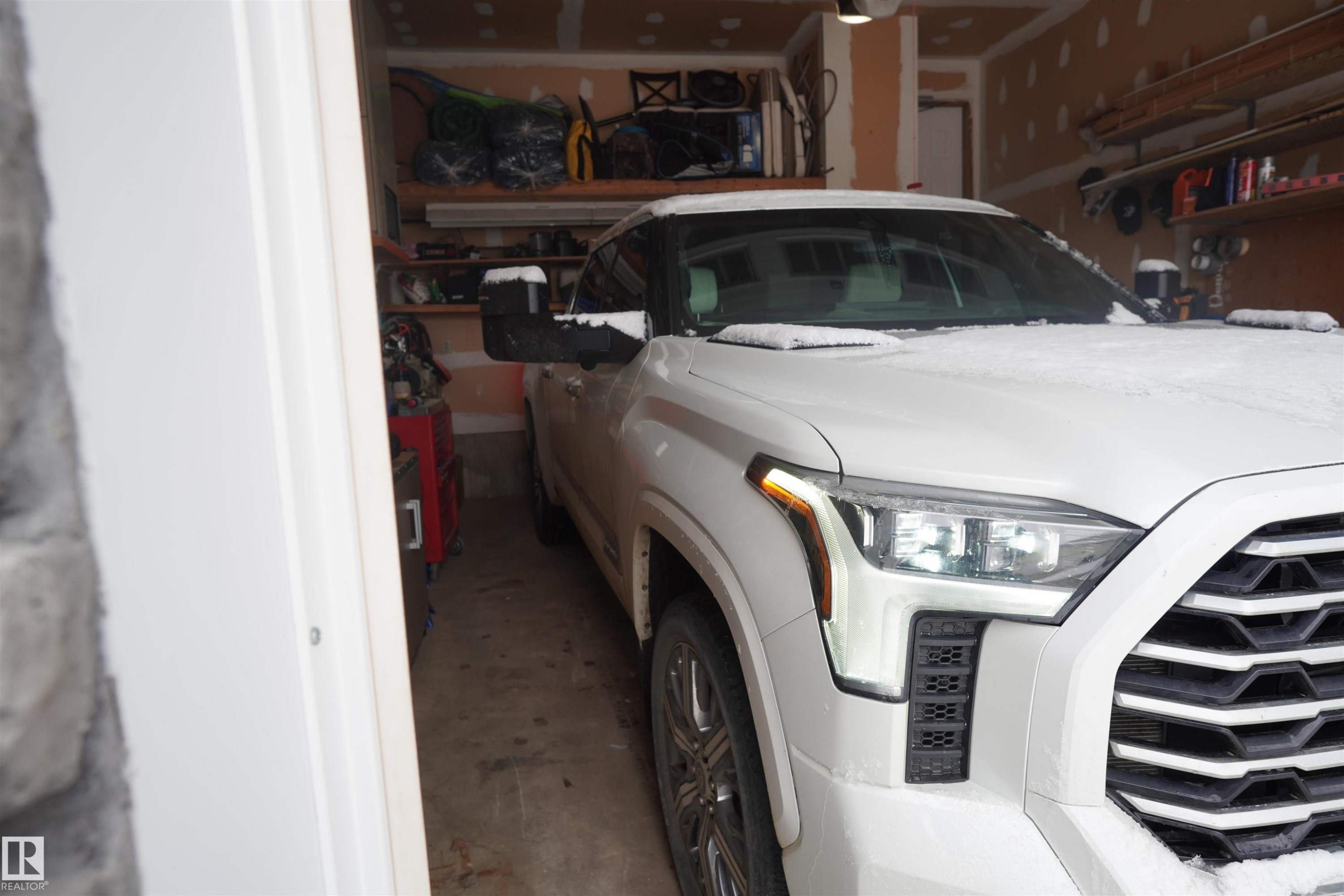 The garage features exposed wood beams and offers built-in shelving for storage - 17819 91A Street, Edmonton, AB - Indoor Photo Showing Garage