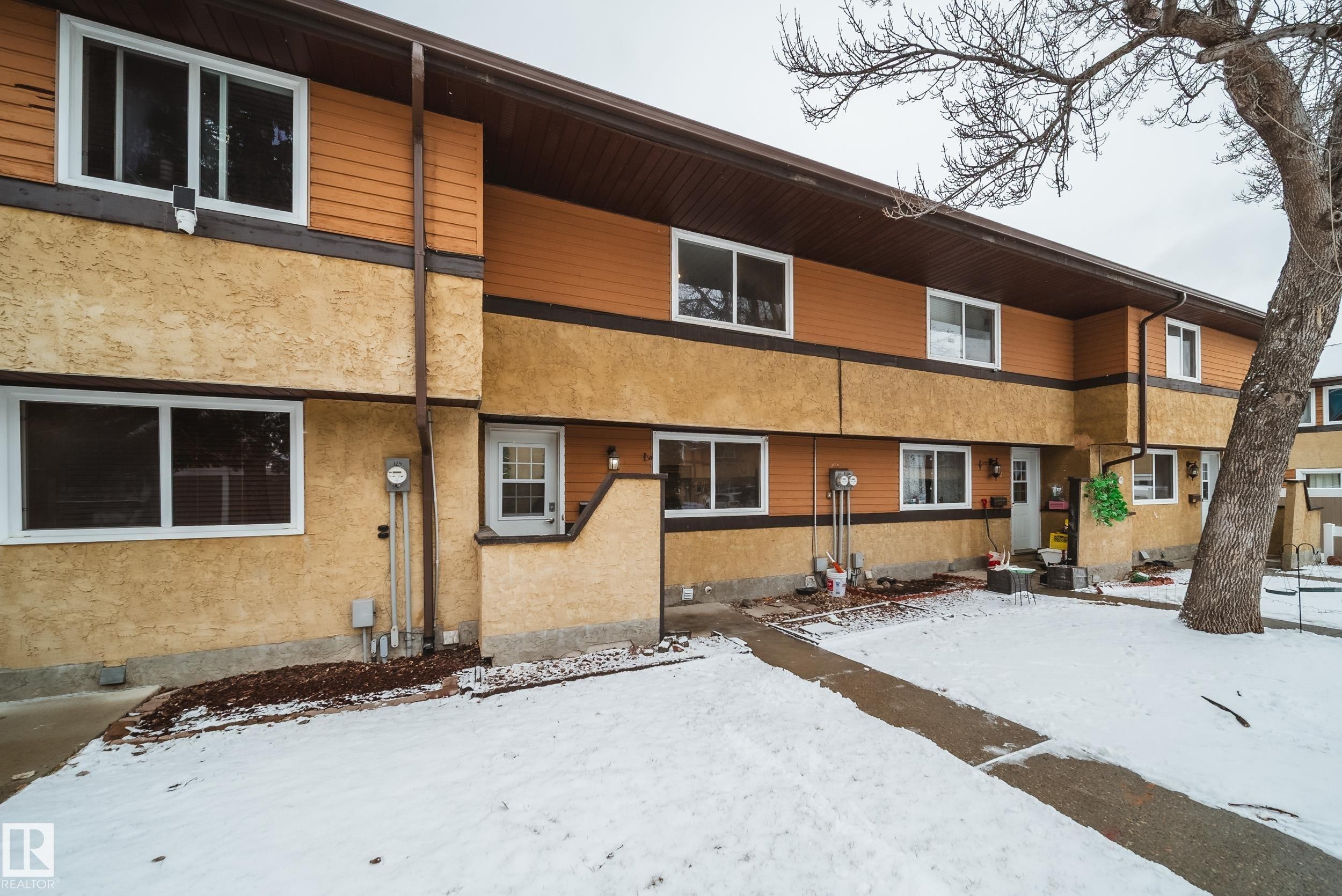 The property features a multi-level facade with horizontal siding and stucco finishes, complemented by white-framed windows - 125 Woodborough Way, Edmonton, AB - Outdoor With Exterior
