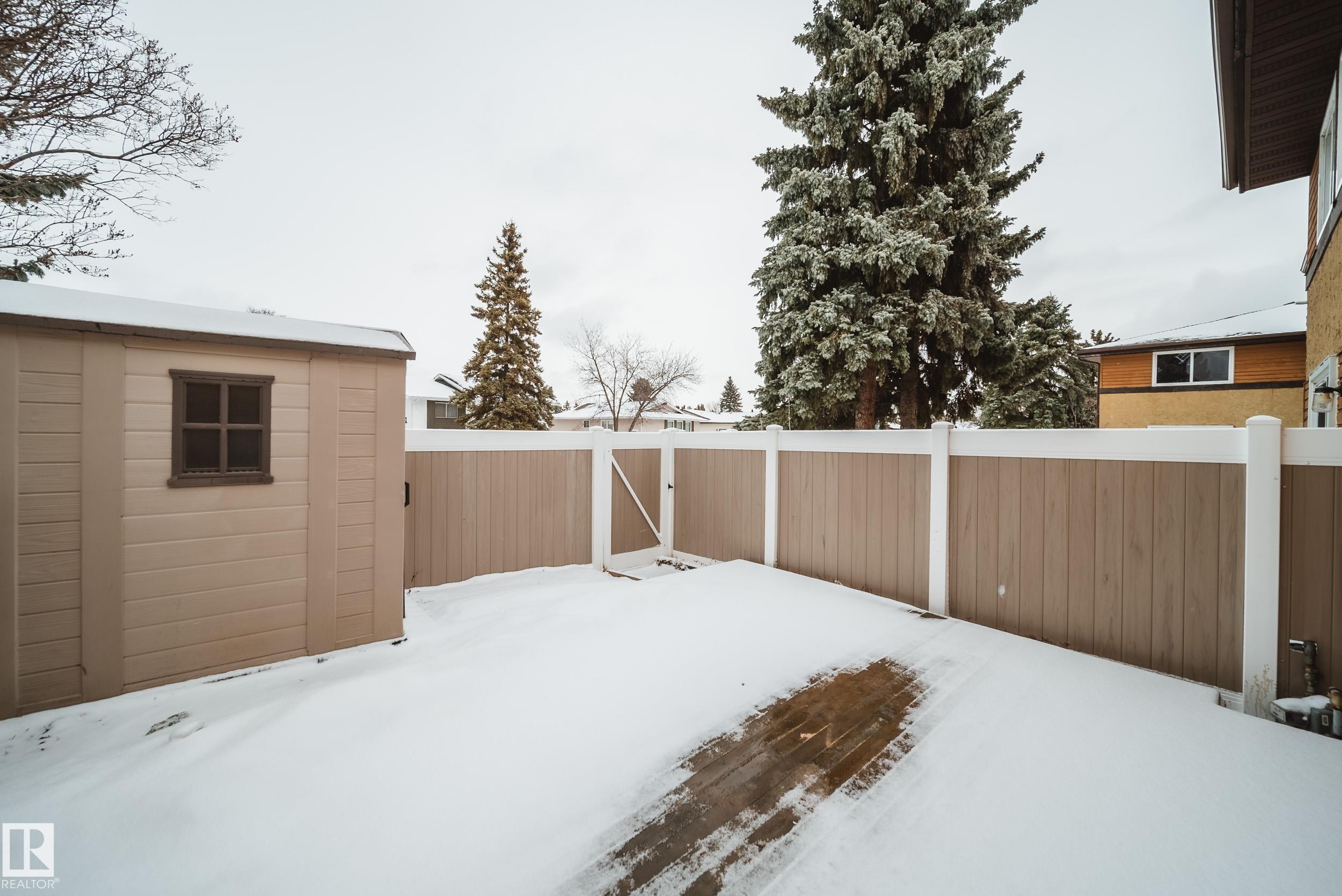 The property includes a spacious backyard with a composite fence and a storage shed - 125 Woodborough Way, Edmonton, AB - Outdoor