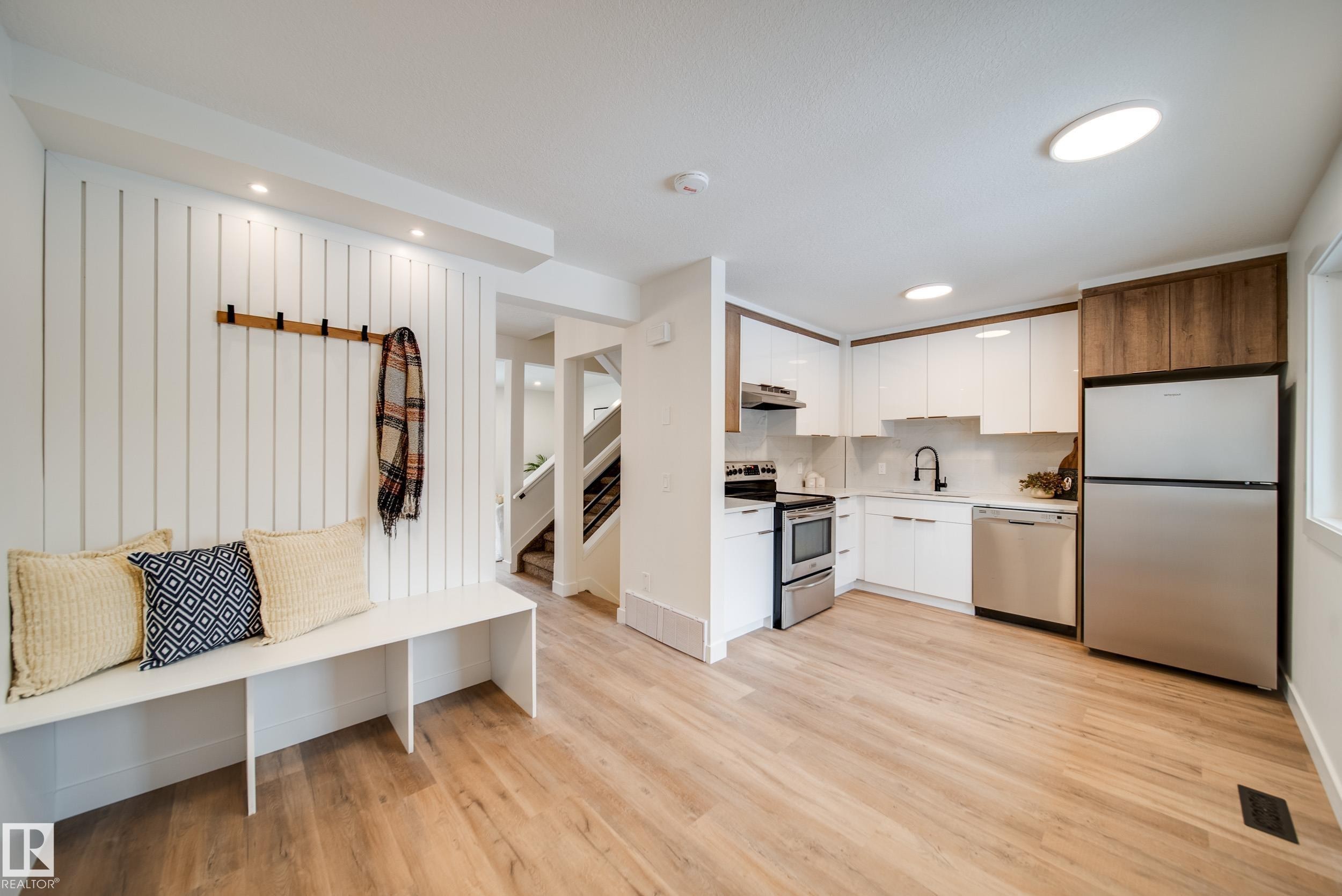 The property features an open-concept layout with light wood flooring throughout - 125 Woodborough Way, Edmonton, AB - Indoor Photo Showing Kitchen