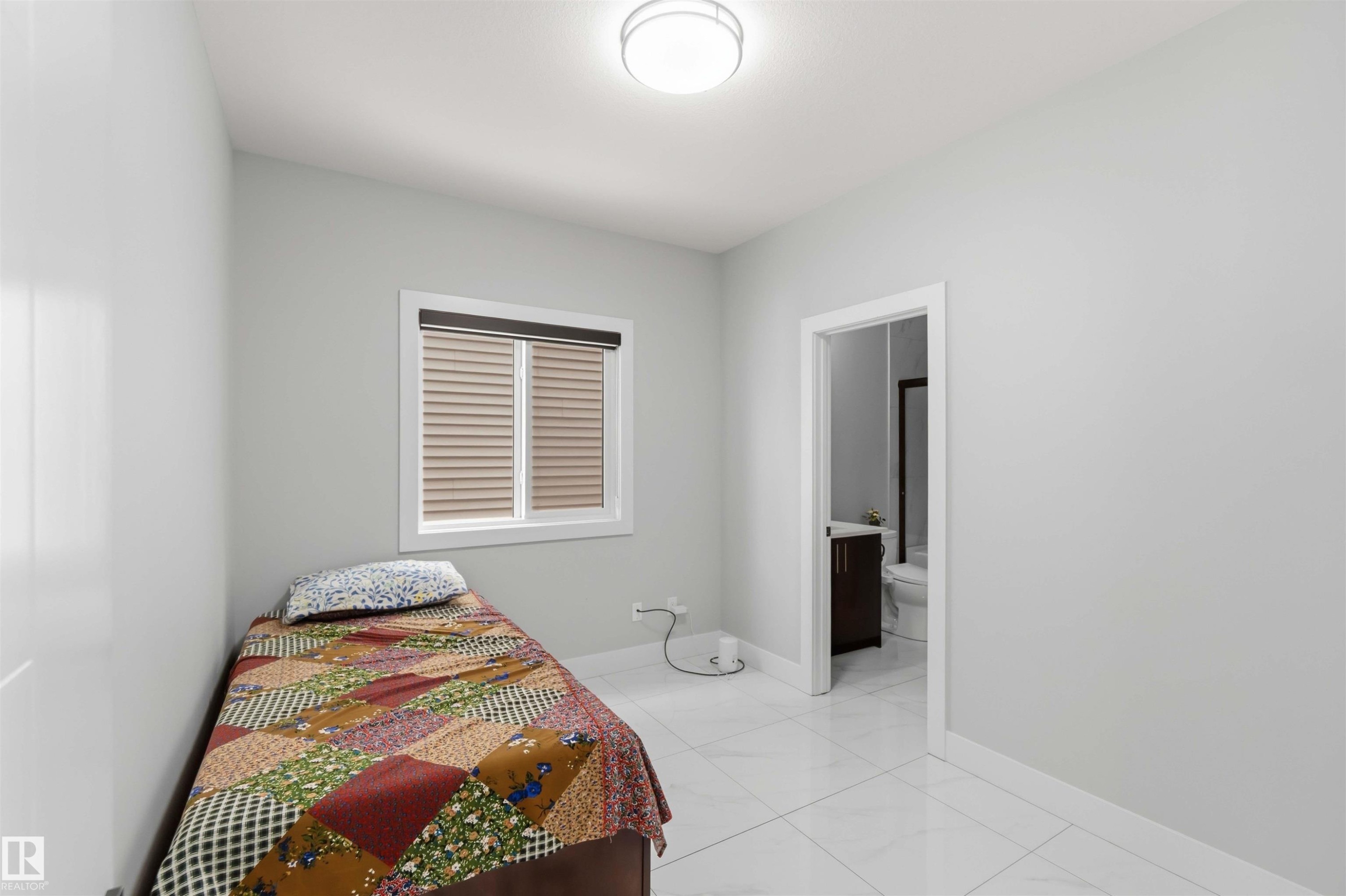 Bright room featuring a window with blinds, a ceiling light fixture, and white tile flooring - 1520 151 Avenue, Edmonton, AB - Indoor Photo Showing Bedroom