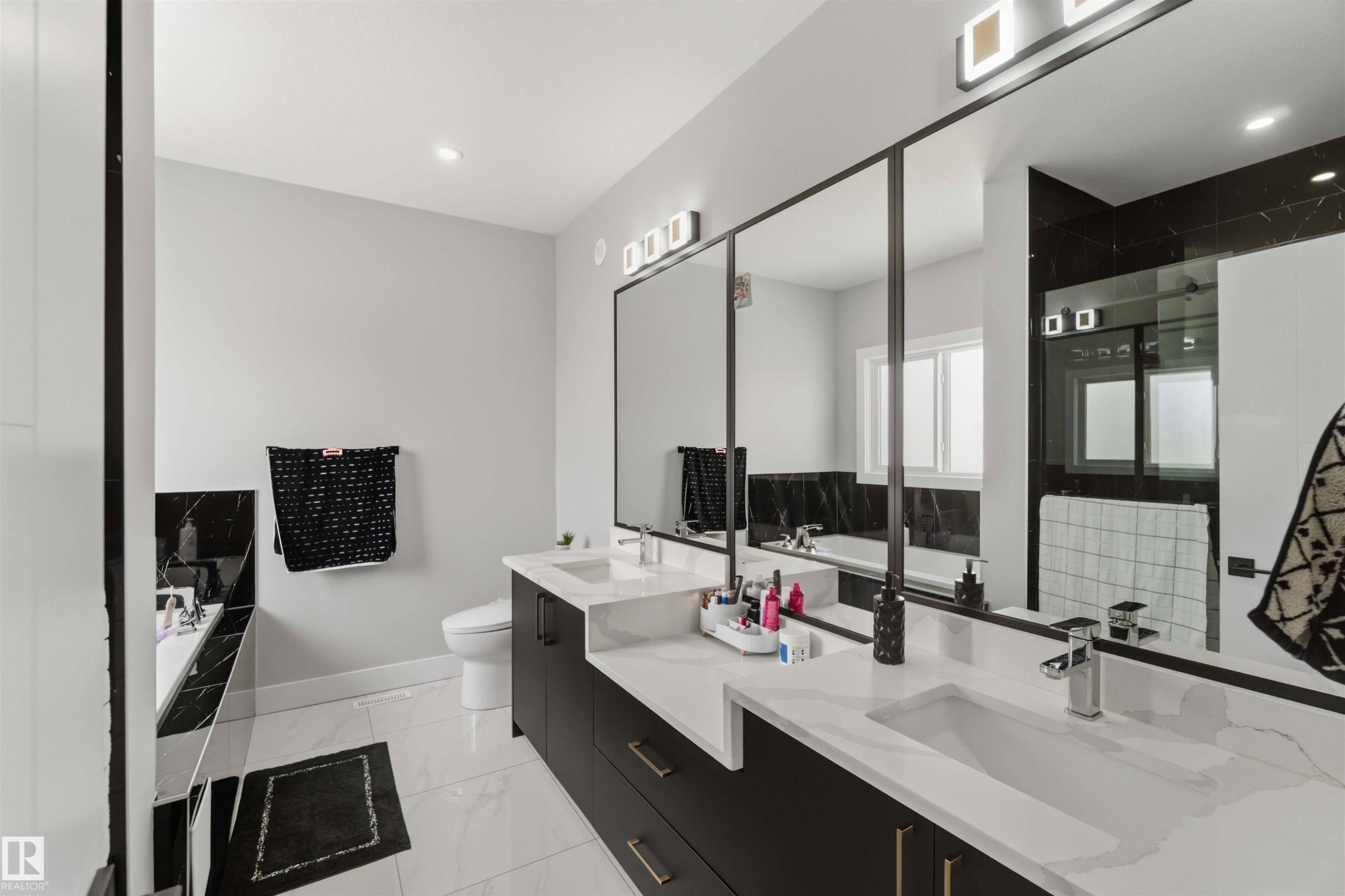 Modern bathroom featuring a dual vanity with rectangular sinks, black cabinetry, and light-colored countertops - 1520 151 Avenue, Edmonton, AB - Indoor Photo Showing Bathroom