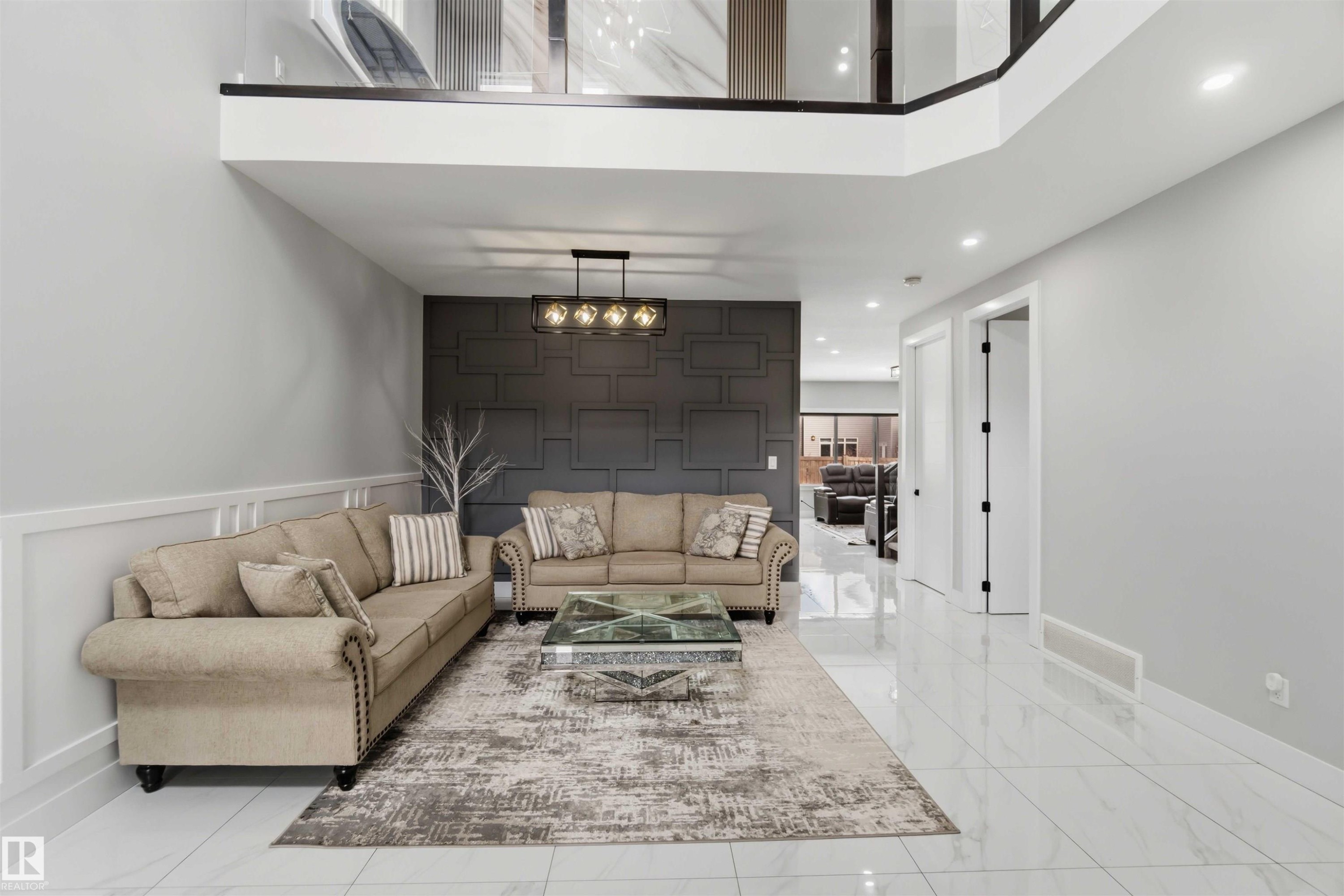 The living area features a high ceiling, recessed lighting, and a decorative wall panel - 1520 151 Avenue, Edmonton, AB - Indoor Photo Showing Living Room