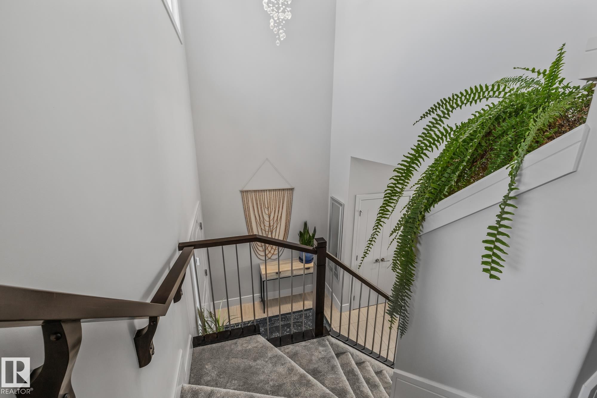 Staircase featuring dark wood handrails, black metal balusters, and carpeted stairs - 3864 Robins Crescent, Edmonton, AB - Indoor Photo Showing Other Room