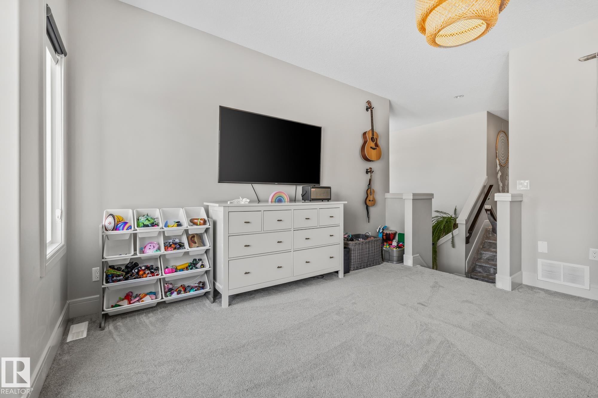 Inviting living area featuring light gray walls, plush gray carpeting, and a large window providing natural light - 3864 Robins Crescent, Edmonton, AB - Indoor Photo Showing Bedroom