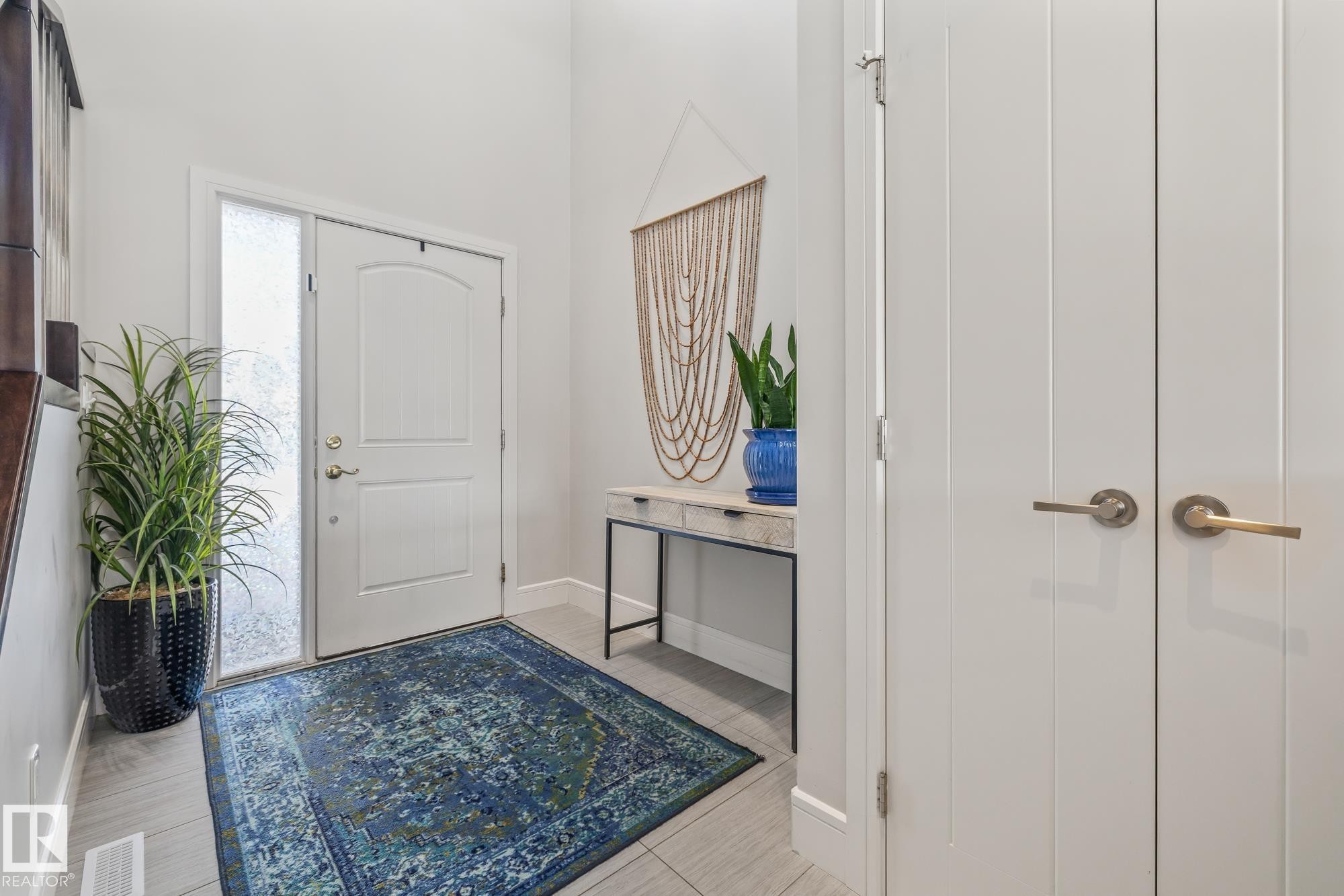 Inviting entryway with a white front door featuring a decorative arch and a frosted glass sidelight - 3864 Robins Crescent, Edmonton, AB - Indoor Photo Showing Other Room