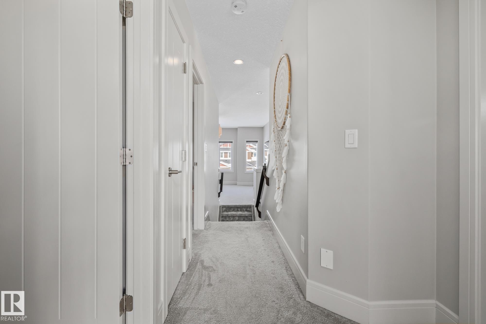 The property features a bright hallway with light grey walls, white trim, and a grey carpet - 3864 Robins Crescent, Edmonton, AB - Indoor Photo Showing Other Room