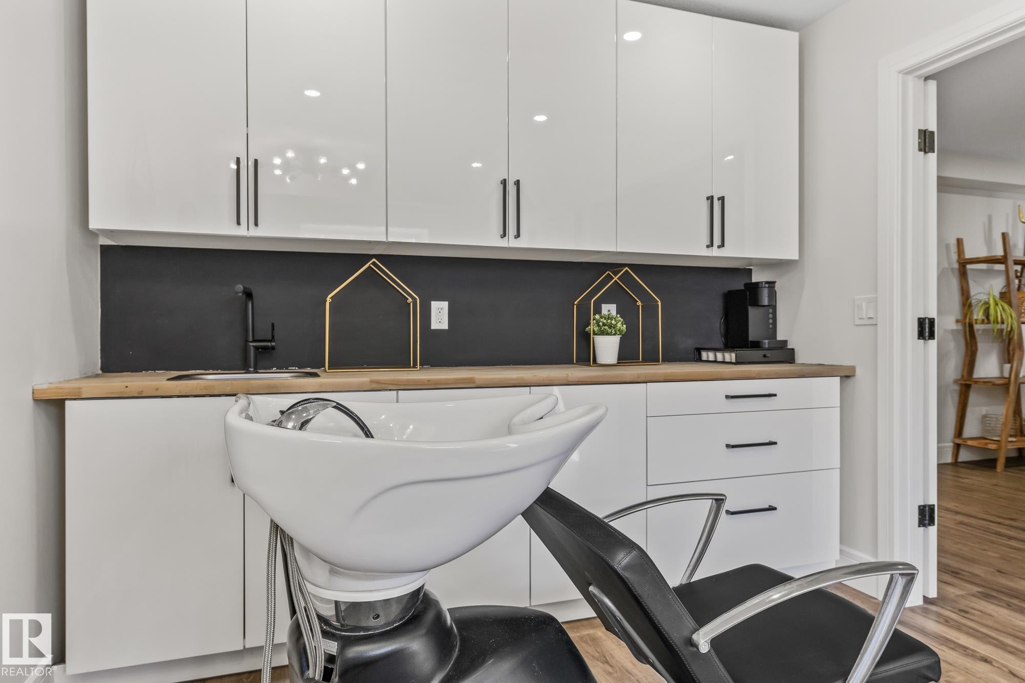 Contemporary space featuring white cabinetry with black hardware, a wooden countertop, a black sink, and a black faucet - 3864 Robins Crescent, Edmonton, AB - Indoor Photo Showing Other Room