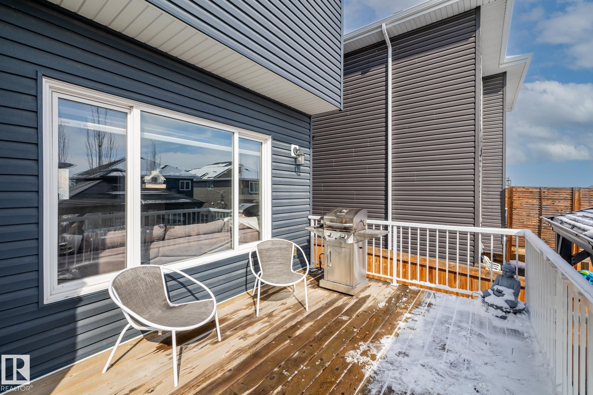 The property features a private deck with wooden flooring and a white railing, providing outdoor living space - 3864 Robins Crescent, Edmonton, AB - Outdoor With Deck Patio Veranda