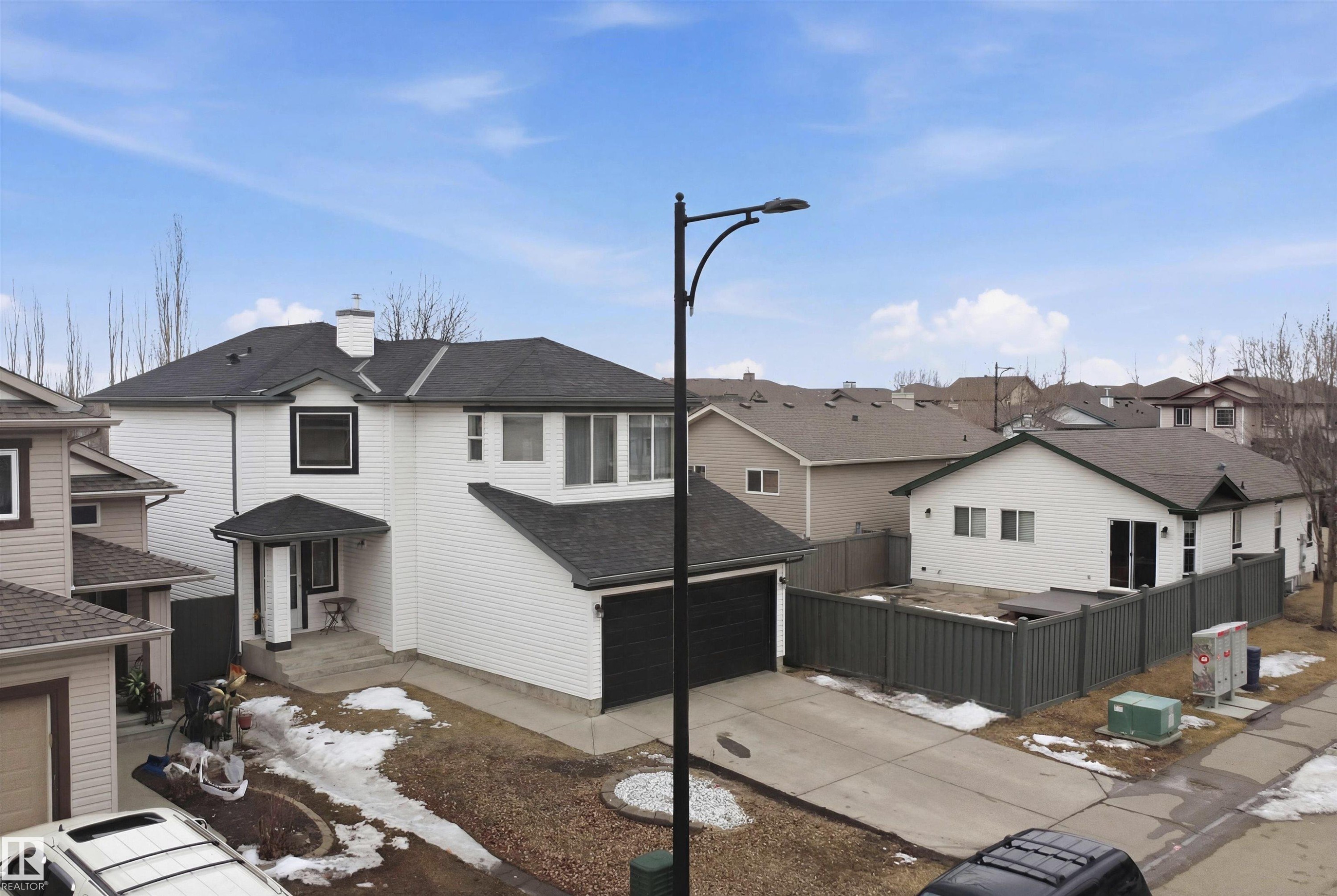 The property features a two-story design with white siding and a dark roof, including an attached garage - 4619 202 Street, Edmonton, AB - Outdoor
