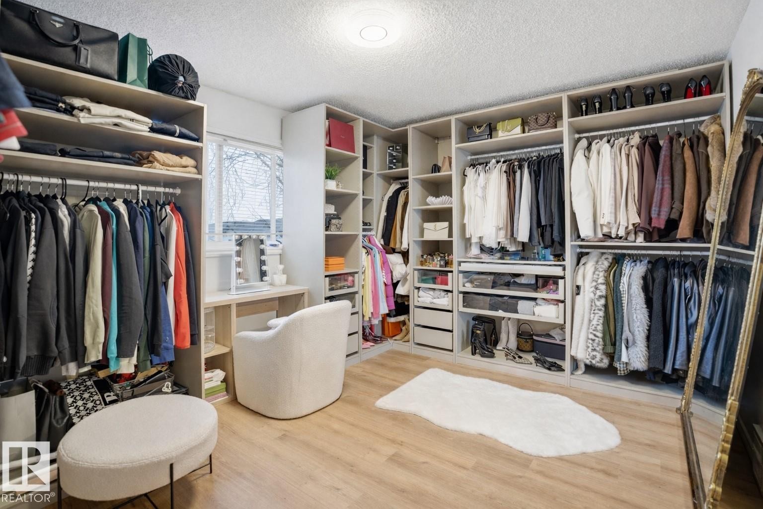 This space features extensive built-in custom closet systems with ample hanging rods and shelving - 4619 202 Street, Edmonton, AB - Indoor With Storage