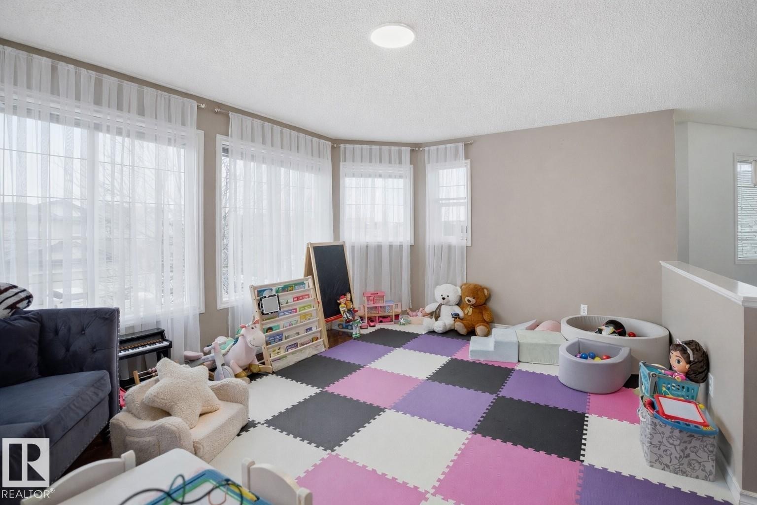 The property features a bright room with light-colored walls and a ceiling light fixture - 4619 202 Street, Edmonton, AB - Indoor