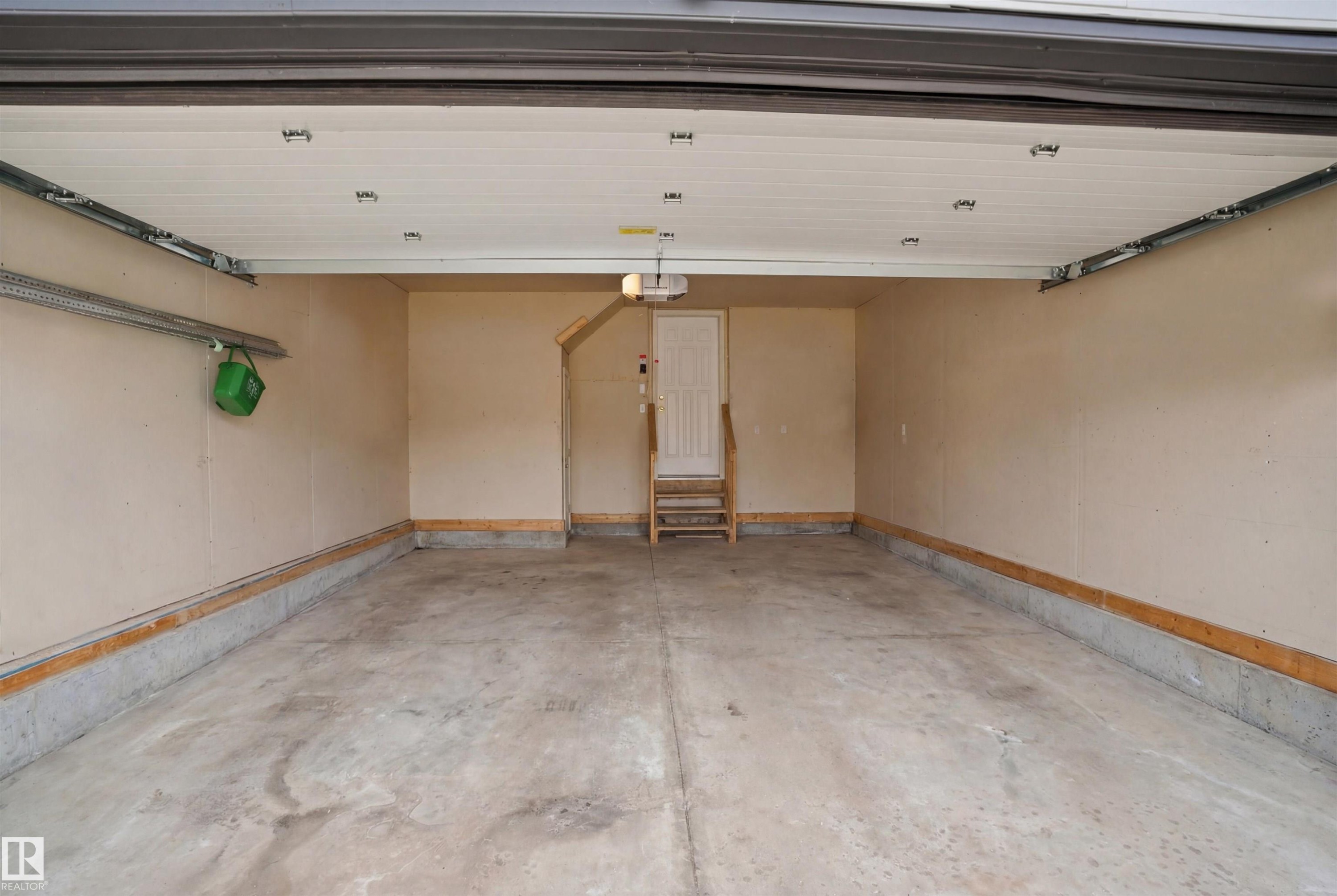 The property includes a spacious garage with a concrete floor, painted walls, and a finished ceiling - 4619 202 Street, Edmonton, AB - Indoor Photo Showing Garage