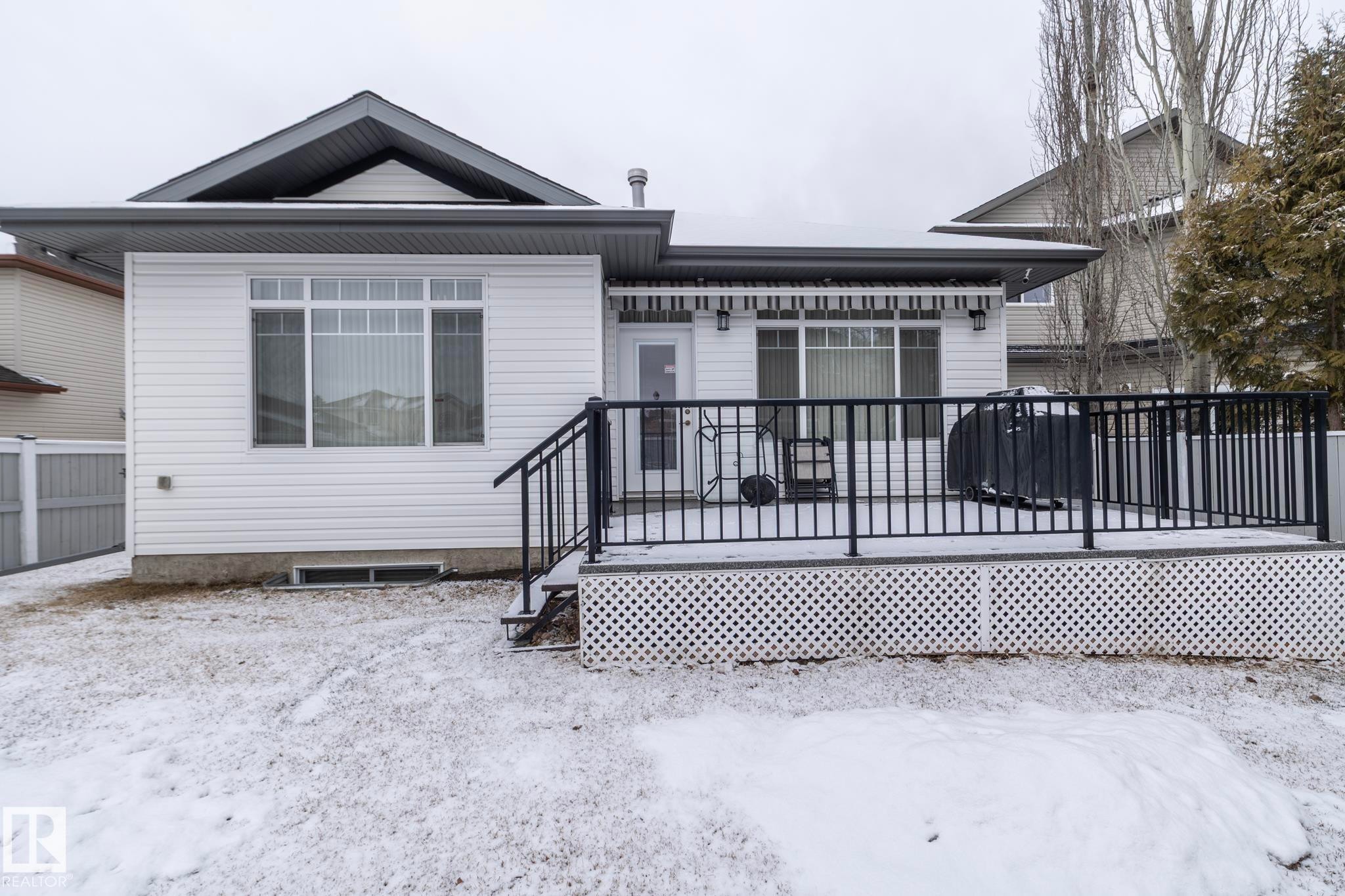 This property features a spacious deck with black railings, accessible via a door from the house - 307 Ravine Close, Devon, AB - Outdoor With Deck Patio Veranda With Exterior