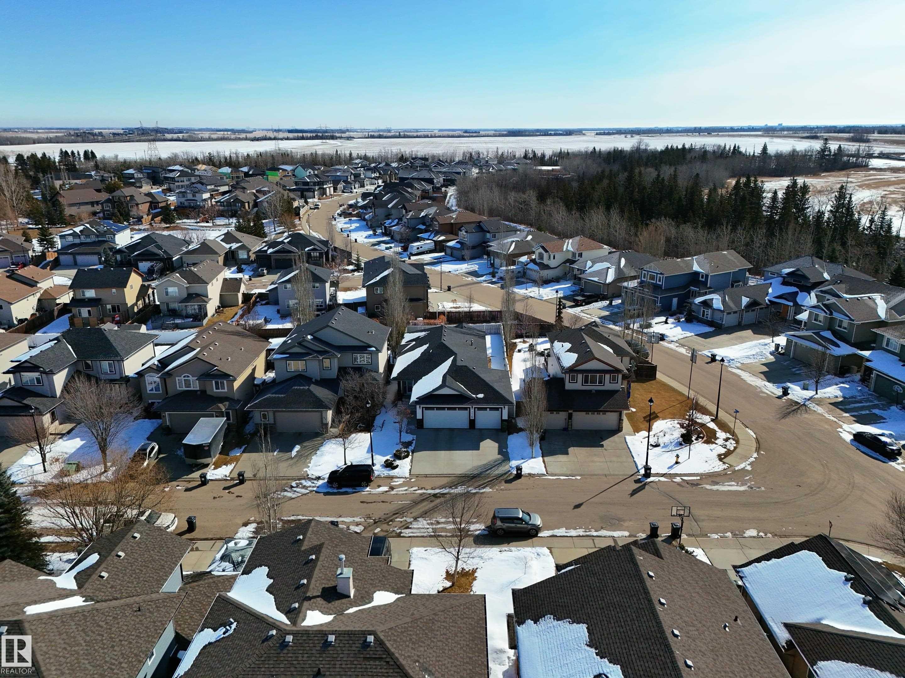 Aerial view of the residential area, showcasing a variety of homes with pitched roofs and driveways - 307 Ravine Close, Devon, AB - Outdoor With View