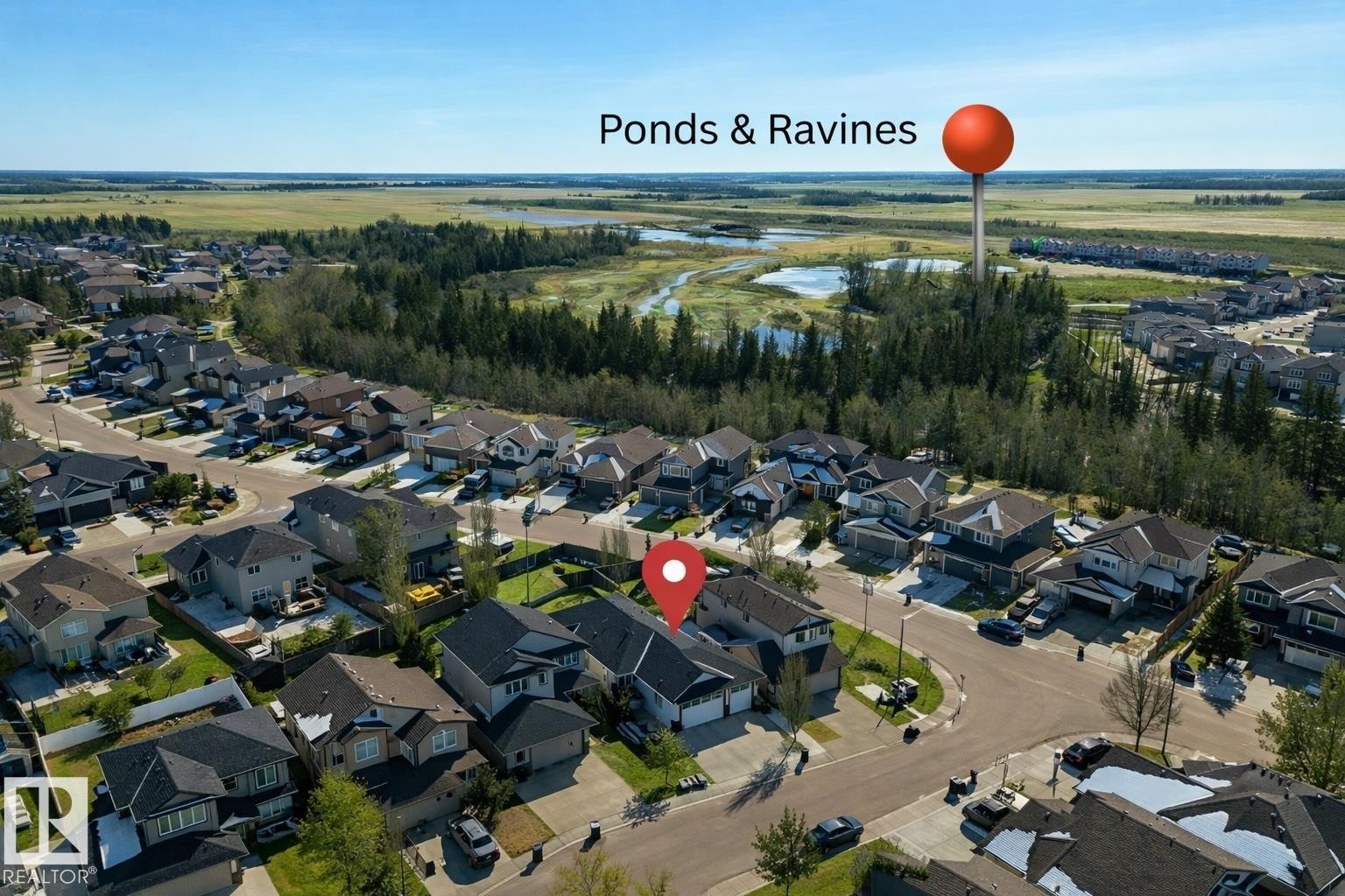 Aerial view showcasing the residential area with surrounding green spaces, including ponds and ravines - 307 Ravine Close, Devon, AB - Outdoor With View
