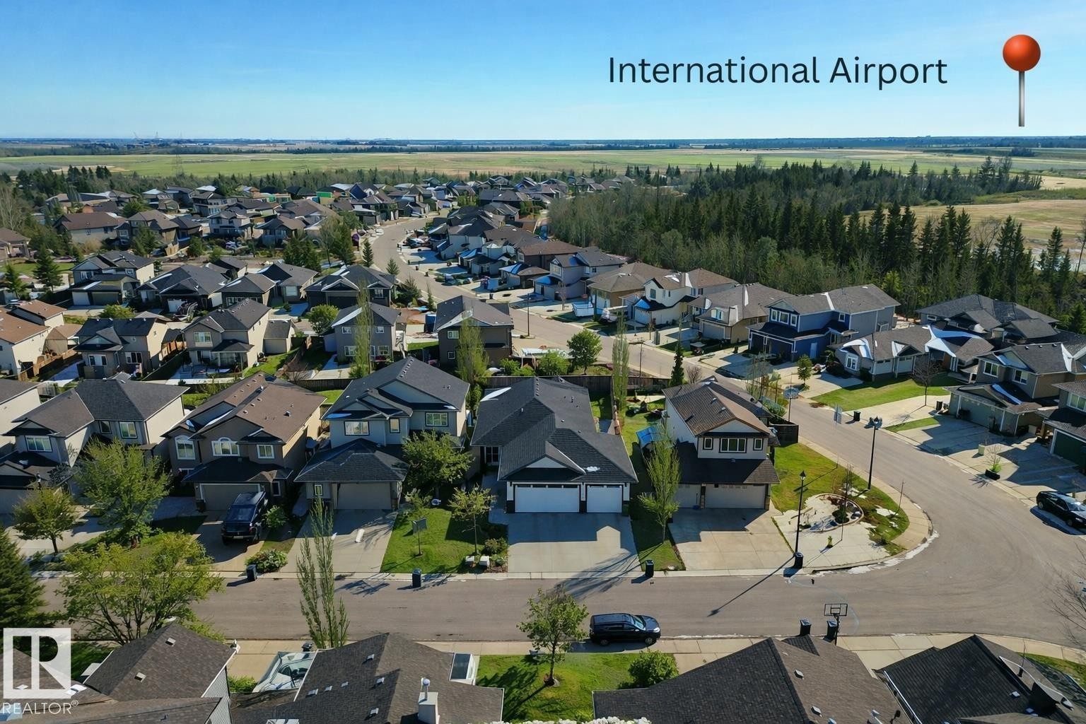 Aerial view of a residential neighbourhood with a diverse collection of homes, mature trees, and paved streets - 307 Ravine Close, Devon, AB - Outdoor With View