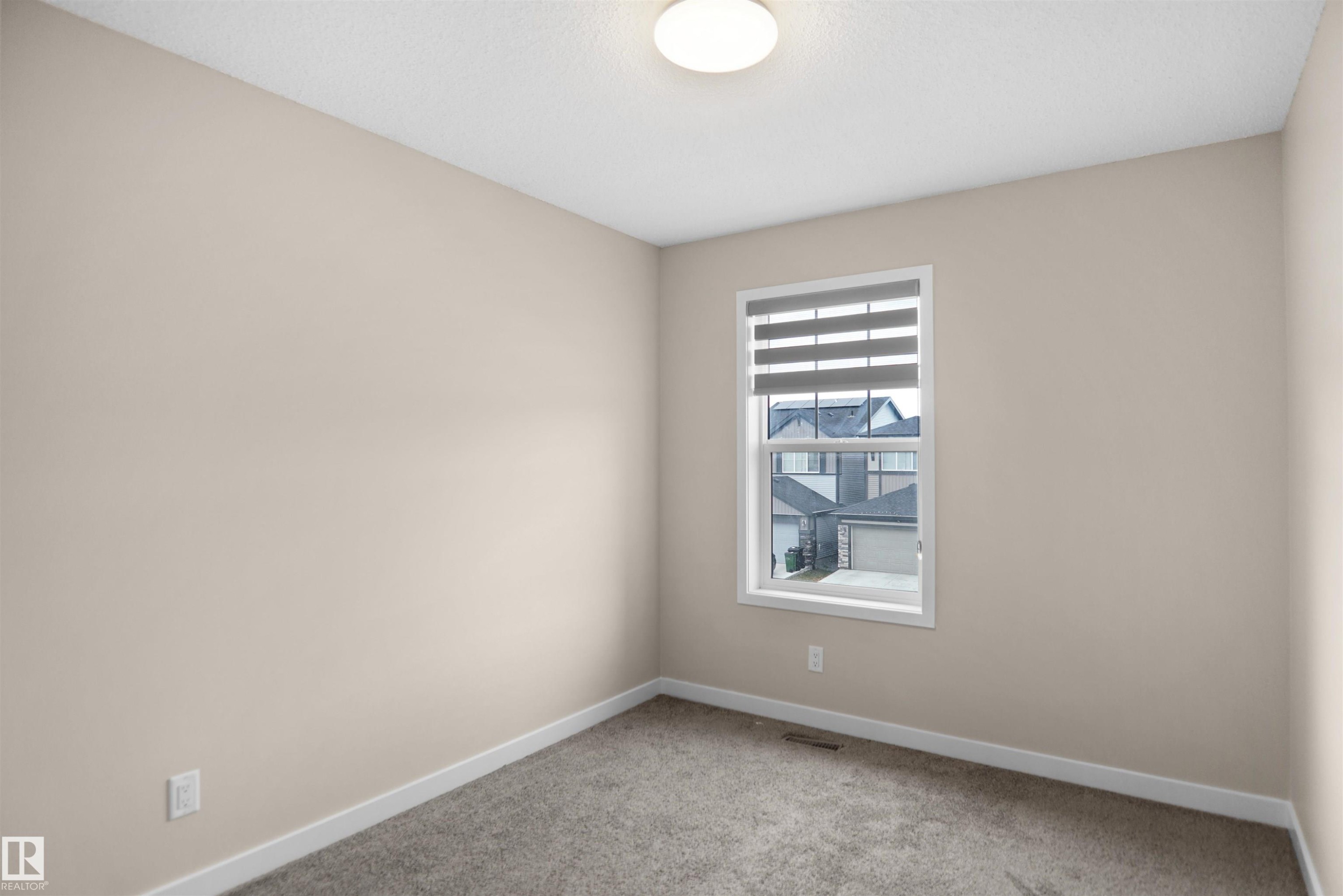This room features carpeted flooring, light neutral-toned walls, and a window with blinds - Edmonton, AB - Indoor Photo Showing Other Room