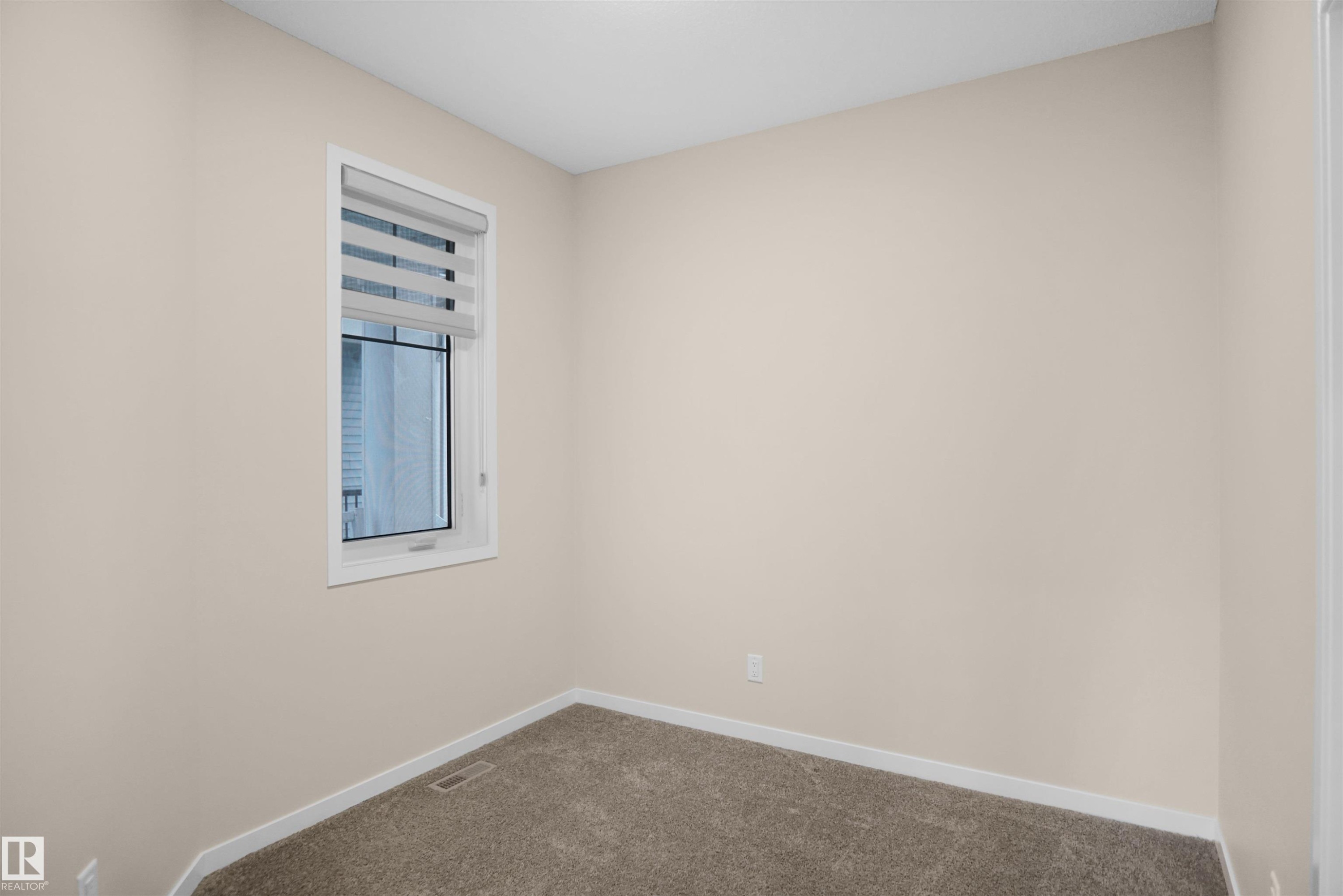 The room features neutral-toned walls, a window with blinds, and carpeted flooring - Edmonton, AB - Indoor Photo Showing Other Room