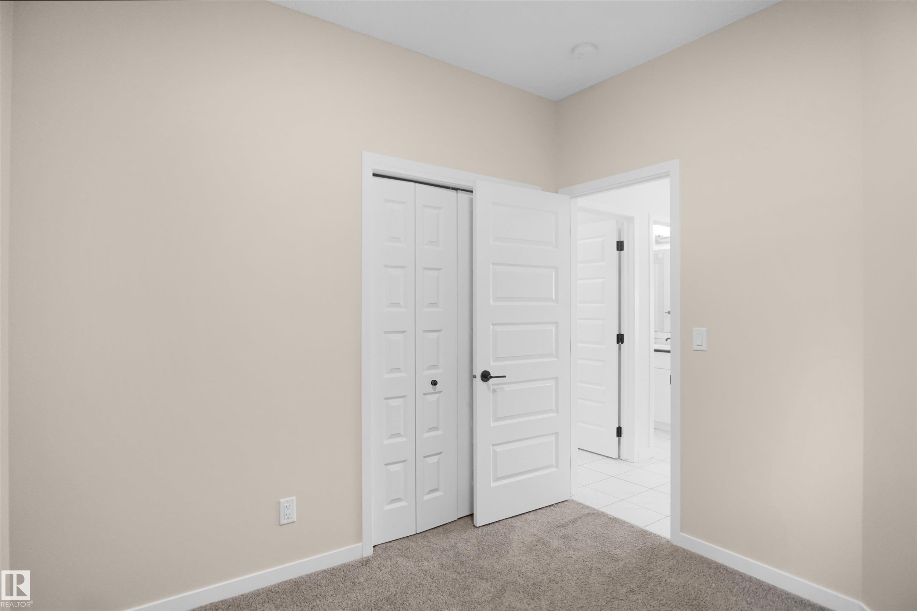 This room features neutral-toned walls, carpeted flooring, and white trim - Edmonton, AB - Indoor Photo Showing Other Room