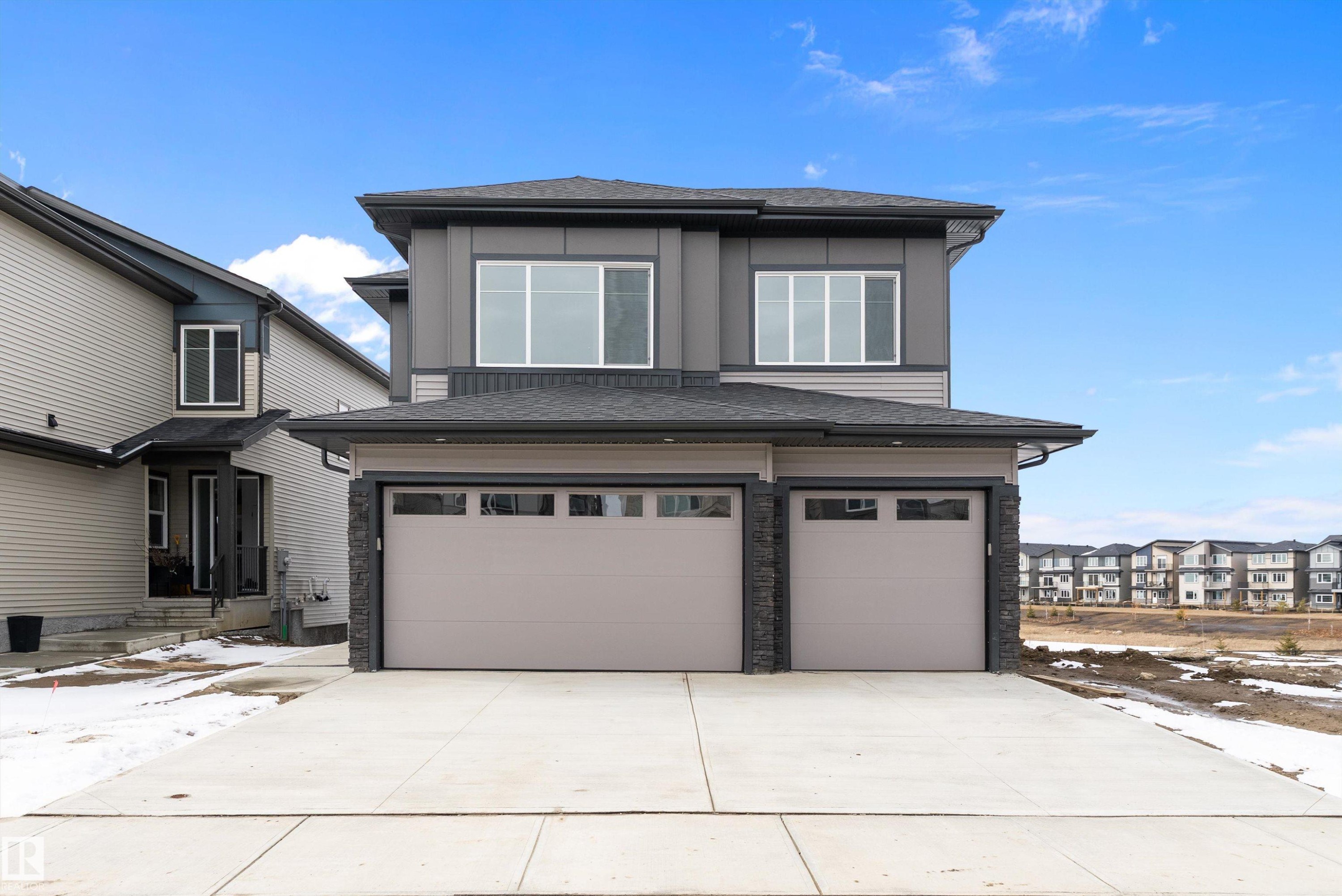 The property features a contemporary exterior with a dark gray and light gray facade - 219 Crystal Creek Dr, Leduc, AB - Outdoor With Facade