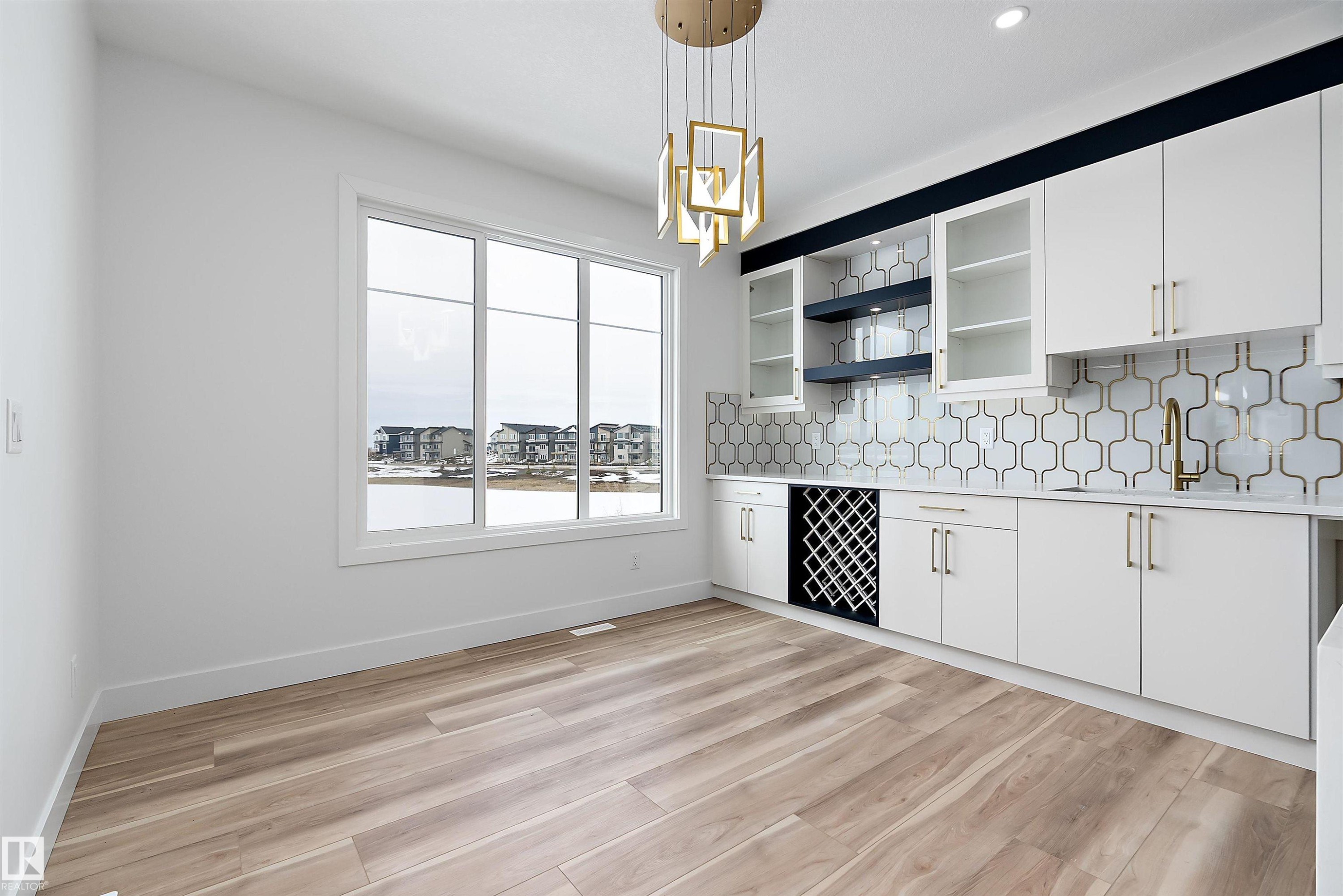 This room features light wood-look flooring and a large window providing expansive views - 219 Crystal Creek Dr, Leduc, AB - Indoor