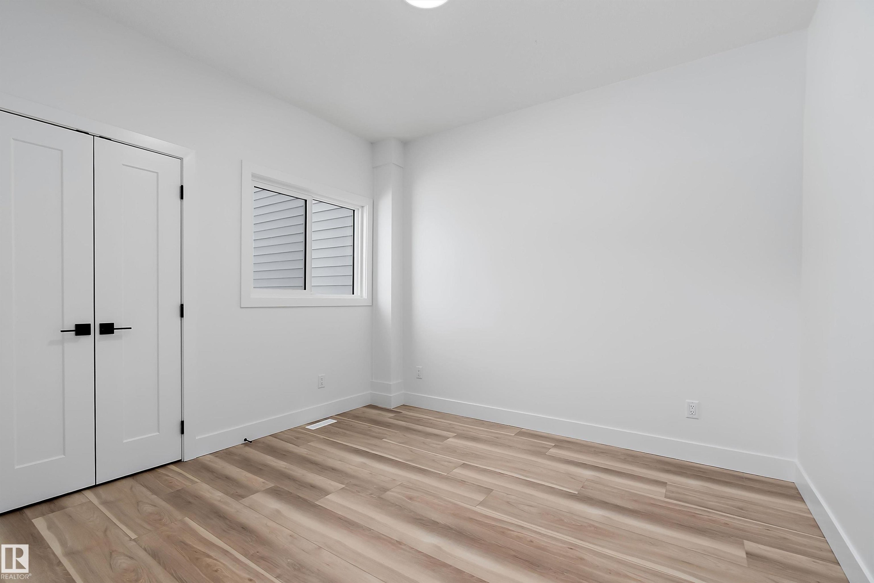 Well-lit room featuring light-toned flooring, white walls, and a window with blinds - 219 Crystal Creek Dr, Leduc, AB - Indoor Photo Showing Other Room