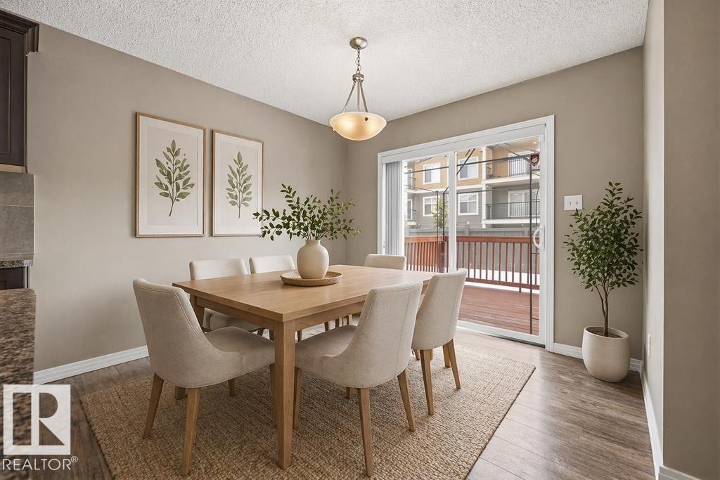 The open concept living area features light wood-style flooring, neutral wall colors, and recessed lighting throughout - 7873 170A Avenue, Edmonton, AB - Indoor Photo Showing Kitchen With Stainless Steel Kitchen