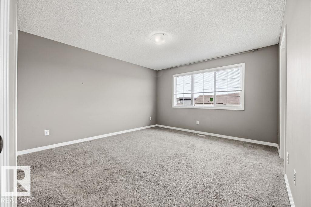 This bathroom features a double vanity with dark cabinetry, light-colored countertops, and two undermount sinks - 7873 170A Avenue, Edmonton, AB - Indoor Photo Showing Bathroom