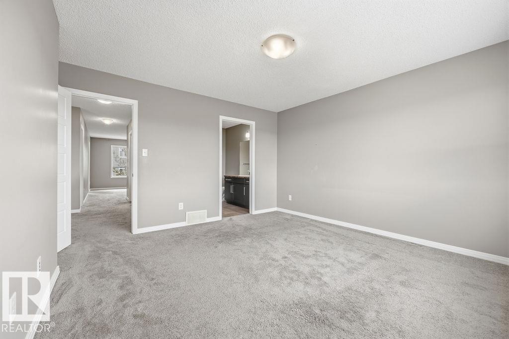 The bathroom features a vanity with a countertop and undermount sink, a shower with a sliding glass door, and tiled flooring - 7873 170A Avenue, Edmonton, AB - Indoor Photo Showing Bathroom